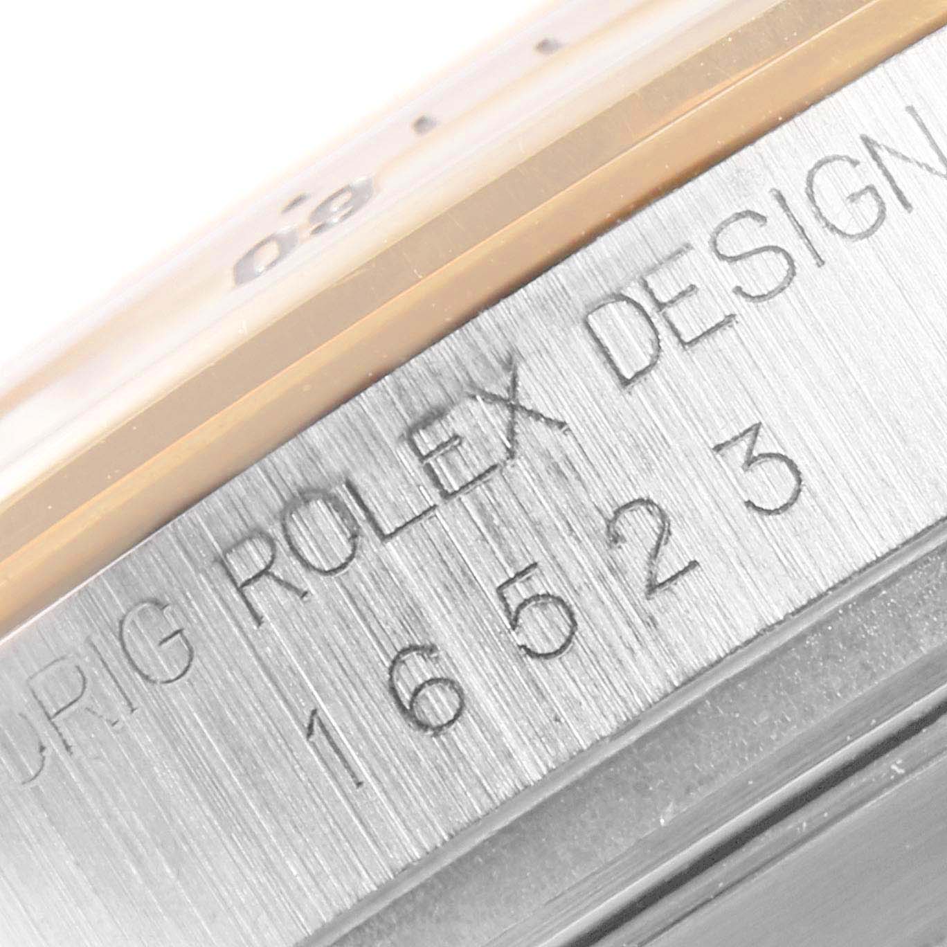 The close-up image shows the model number and design engraving on the bezel of a Rolex Daytona 16523 Men
s Steel and Gold (two tone) Champagne Dial 16523 Men
s Steel and Gold (two tone) Champagne Dial watch.