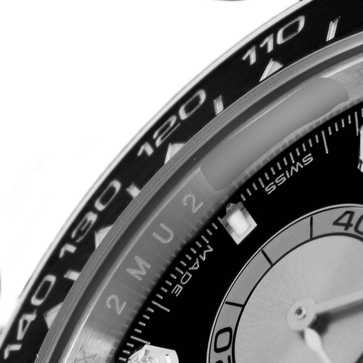 The image shows a close-up of the bezel and part of the dial on a Rolex Daytona 126519 Men's White Gold Black Dial watch.
