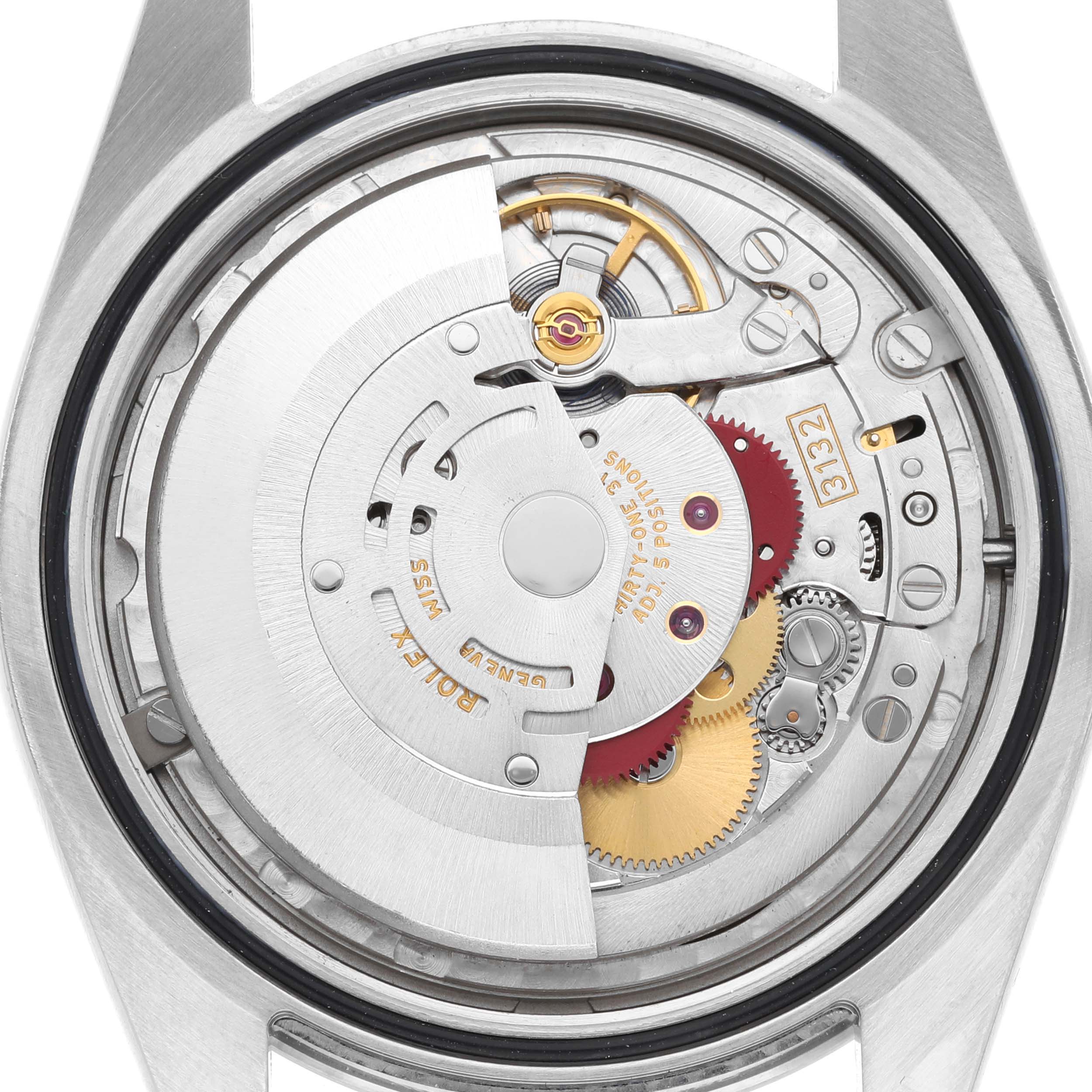 The image shows the movement of a Rolex Explorer 214270 Men's Stainless Steel Black Dial watch from the back, revealing its mechanical components and gears.
