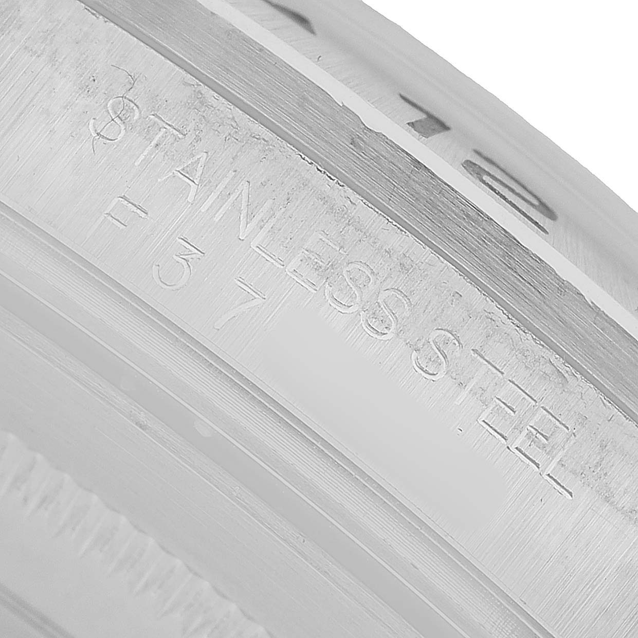 The image shows a close-up of the inner case engraving on a Rolex Explorer 16570 Men's Stainless Steel Black Dial, indicating "STAINLESS STEEL."