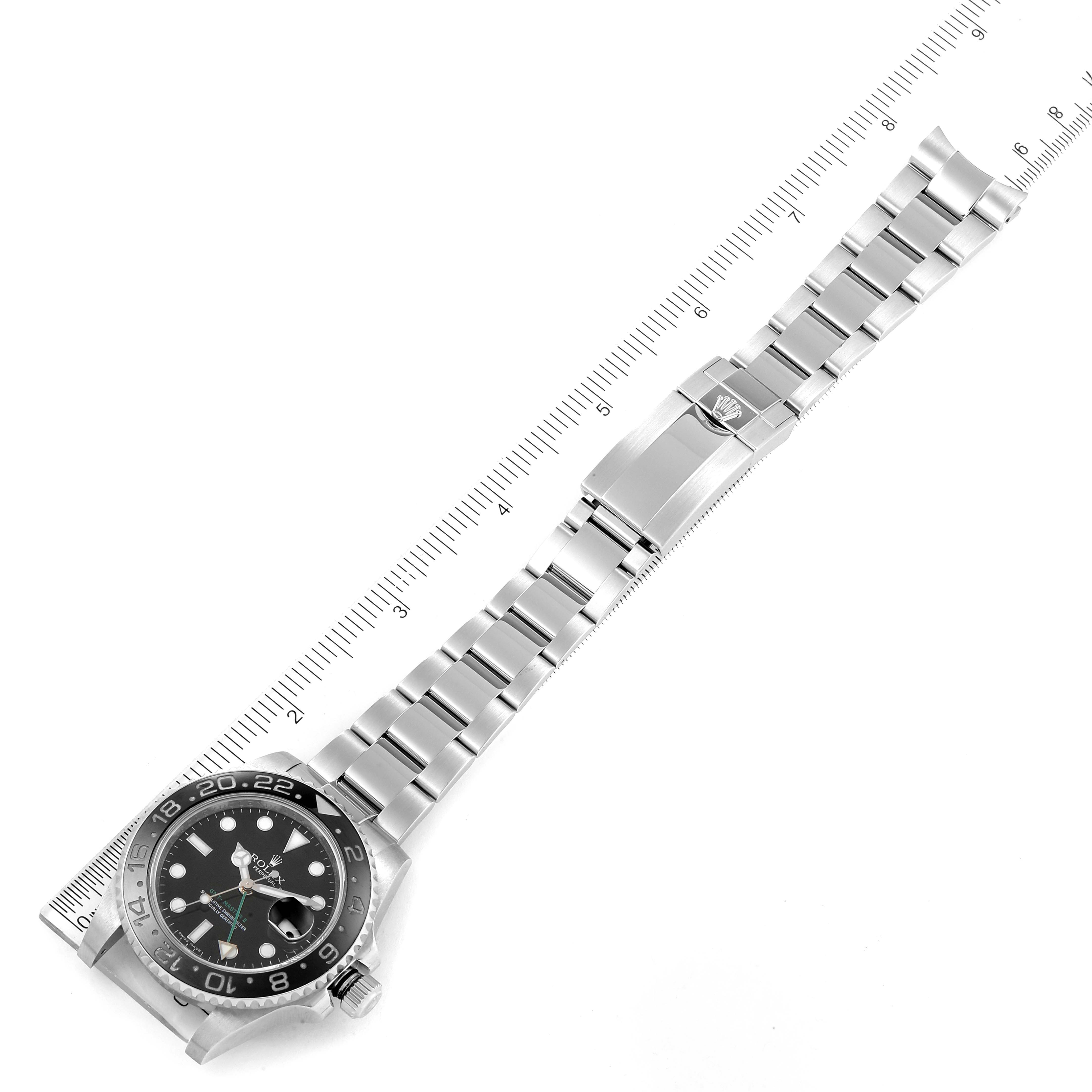 The image shows a top-down view of a Rolex GMT-Master 116710 Men
s Stainless Steel Black Dial 116710 Men
s Stainless Steel Black Dial watch lying flat next to a ruler with the clasp and bracelet visible.