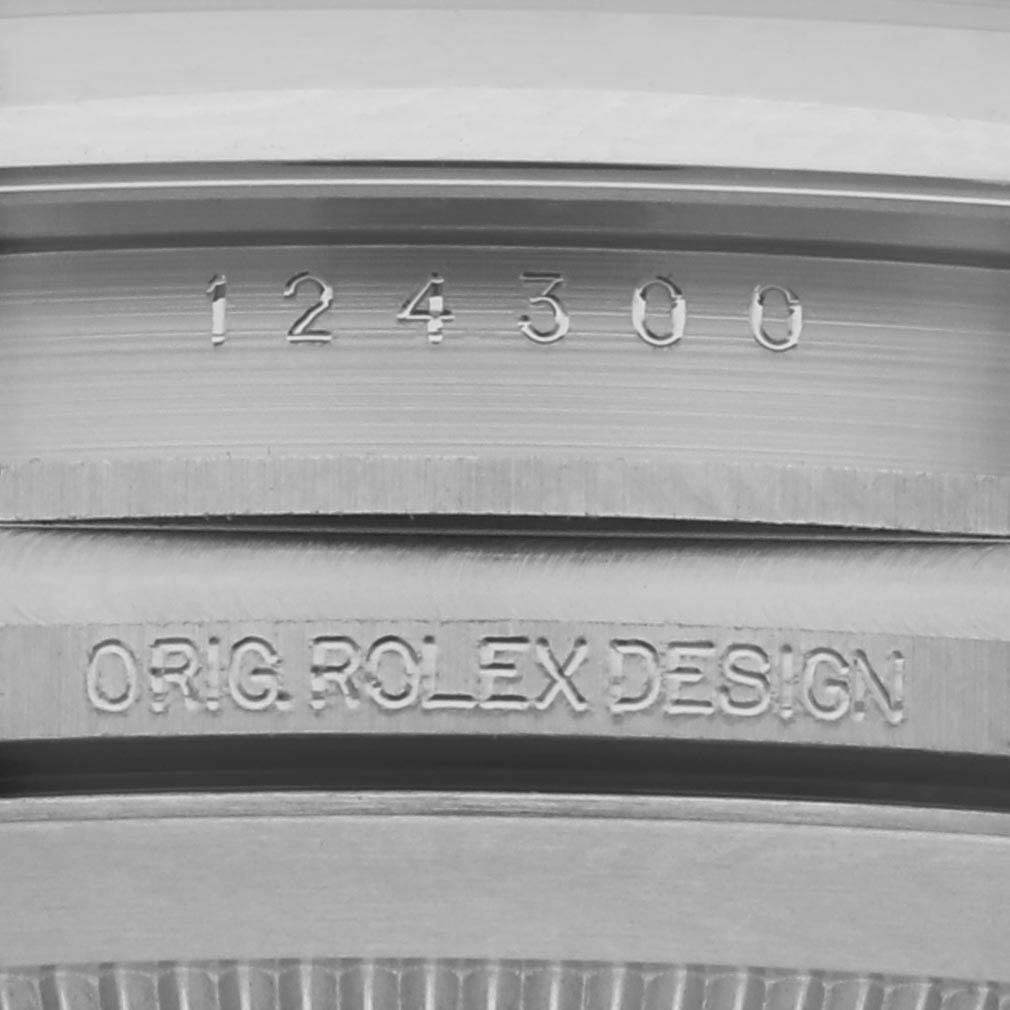 The image shows the engraved serial number and "ORIG. ROLEX DESIGN" on the side of the Rolex Oyster Perpetual 124300 Men
s Stainless Steel Black Dial 124300 Men
s Stainless Steel Black Dial model.