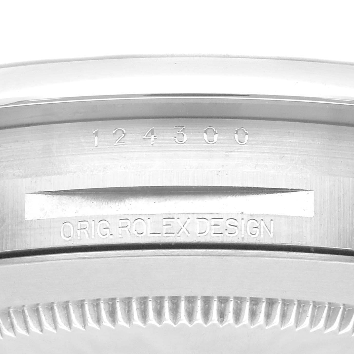 This image shows a close-up of the case back and rim of a Rolex Oyster Perpetual 124300 Men's Stainless Steel Blue Dial 124300 Men's Stainless Steel Blue Dial watch, highlighting the model number and "ORIG. ROLEX DESIGN."