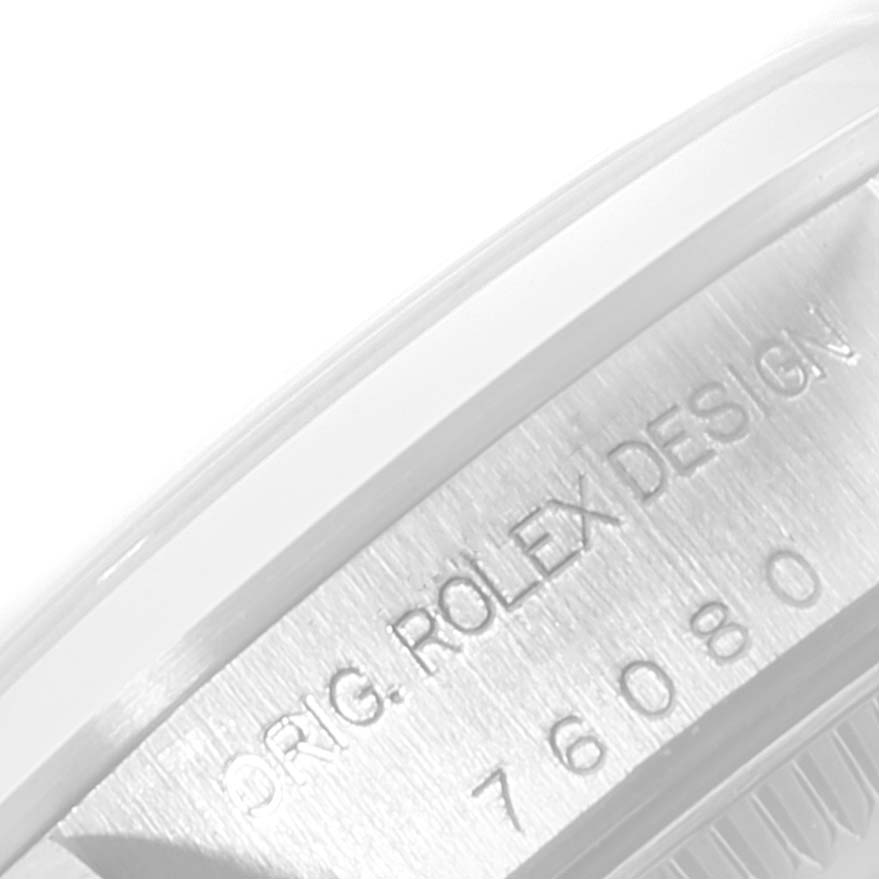 This image shows a close-up of the engraved side of a Rolex Oyster Perpetual 76080 Women's Stainless Steel Pink Dial 76080 Women's Stainless Steel Pink Dial watch case, detailing "ORIG. ROLEX DESIGN" and the model number.
