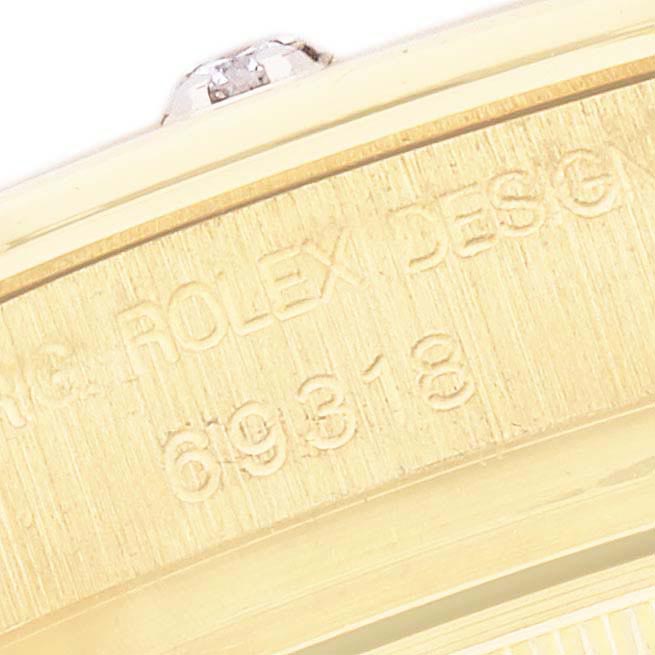 The image shows a close-up angle of the Rolex Pearlmaster 69318 Women
s Yellow Gold White Dial 69318 Women
s Yellow Gold White Dial case with engraved model number details.