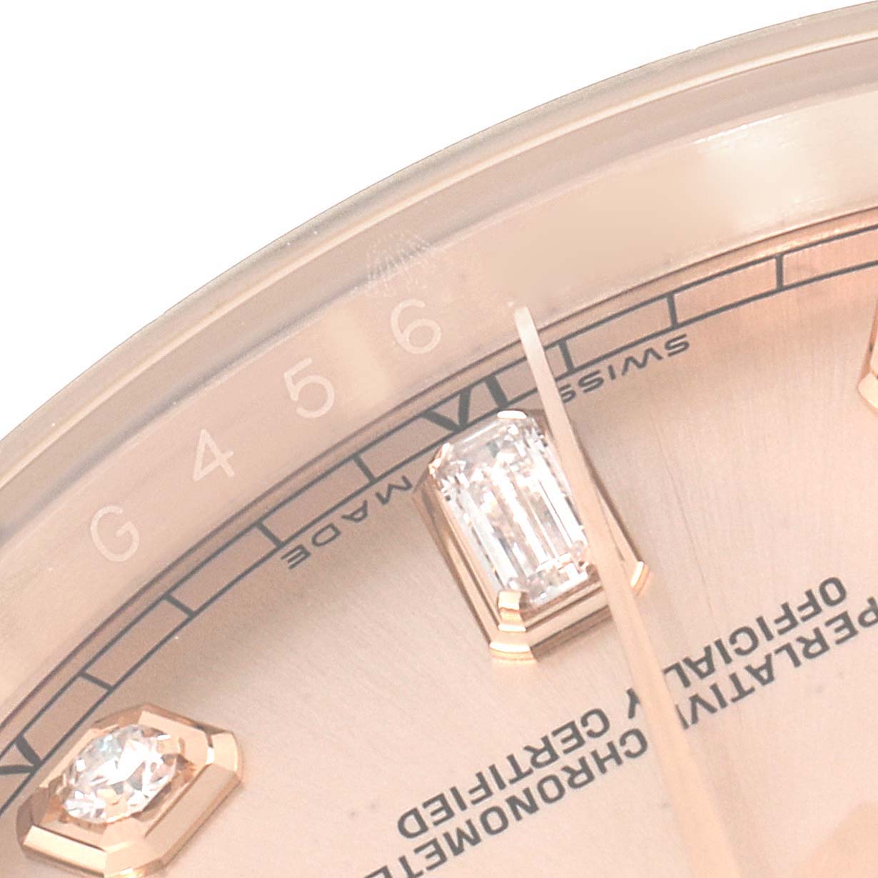 The image shows a close-up of the dial and bezel from a Rolex President 118205 Men's Rose Gold Pink Dial 118205 Men's Rose Gold Pink Dial model watch, focusing on the hour markers and text details.