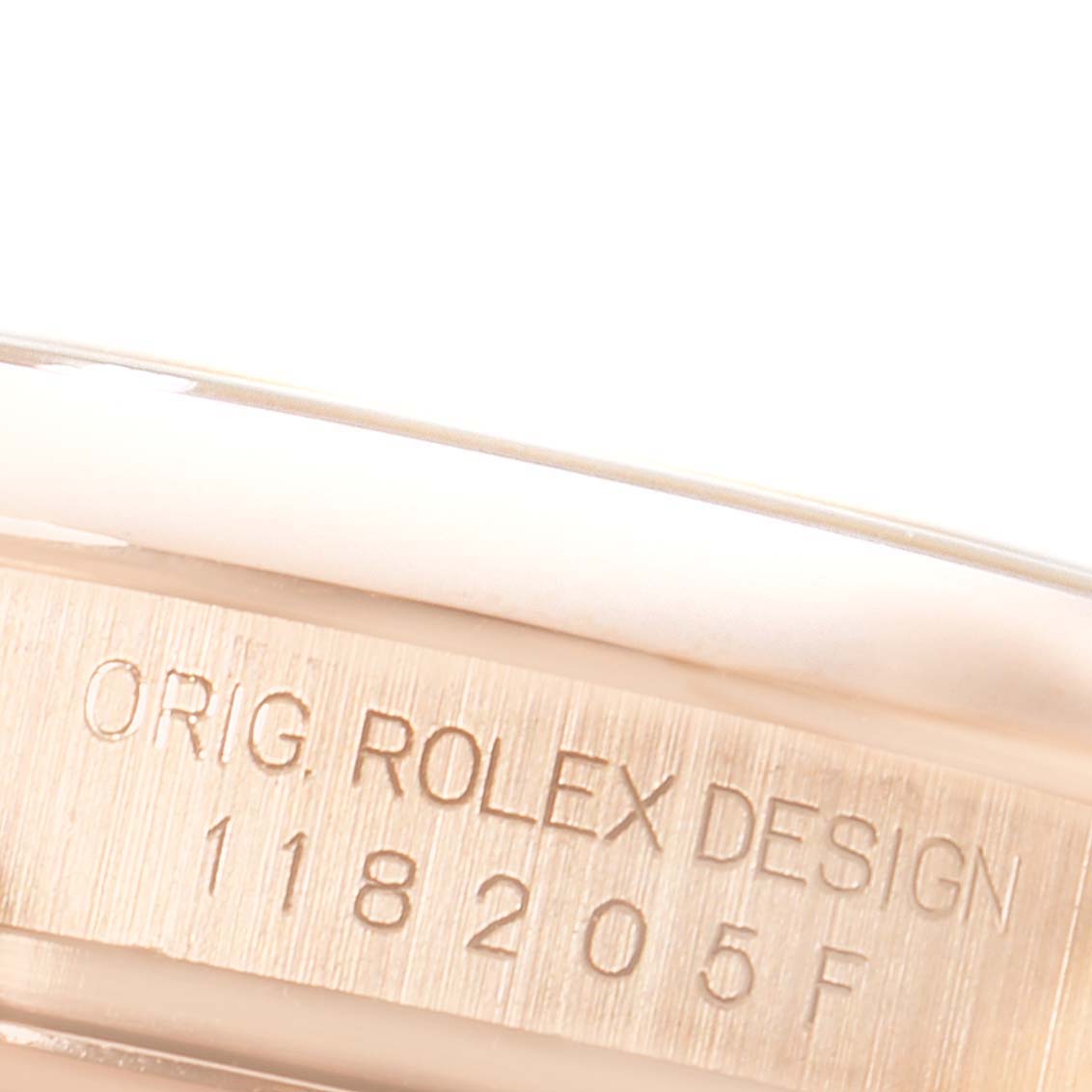 This close-up image shows the engraved model number on the inner case of a Rolex President 118205 Men's Rose Gold Pink Dial 118205 Men's Rose Gold Pink Dial watch.