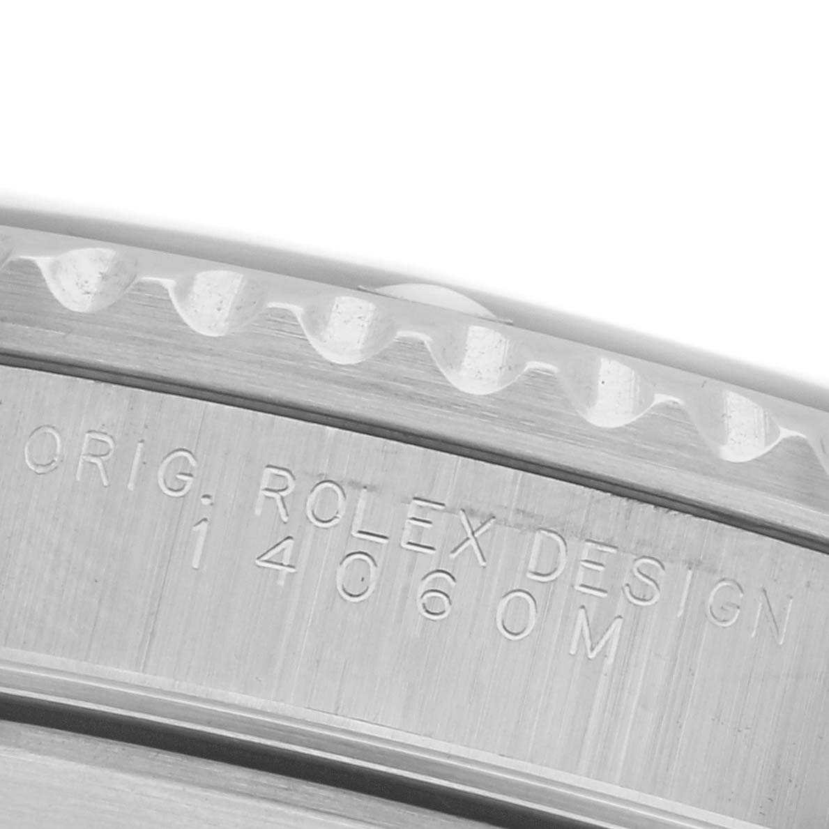 The image shows a close-up of the side of a Rolex Submariner 14060 Men's Stainless Steel Black Dial 14060 Men's Stainless Steel Black Dial's case, featuring engraved text and part of the bezel.