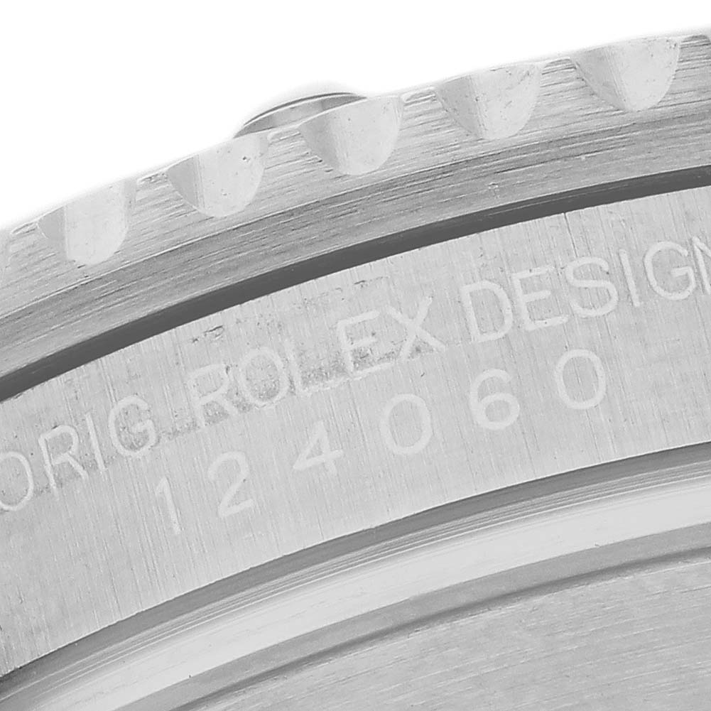 The image shows a close-up of the Rolex Submariner 124060 Men's Stainless Steel Black Dial's case side with engraved design details.