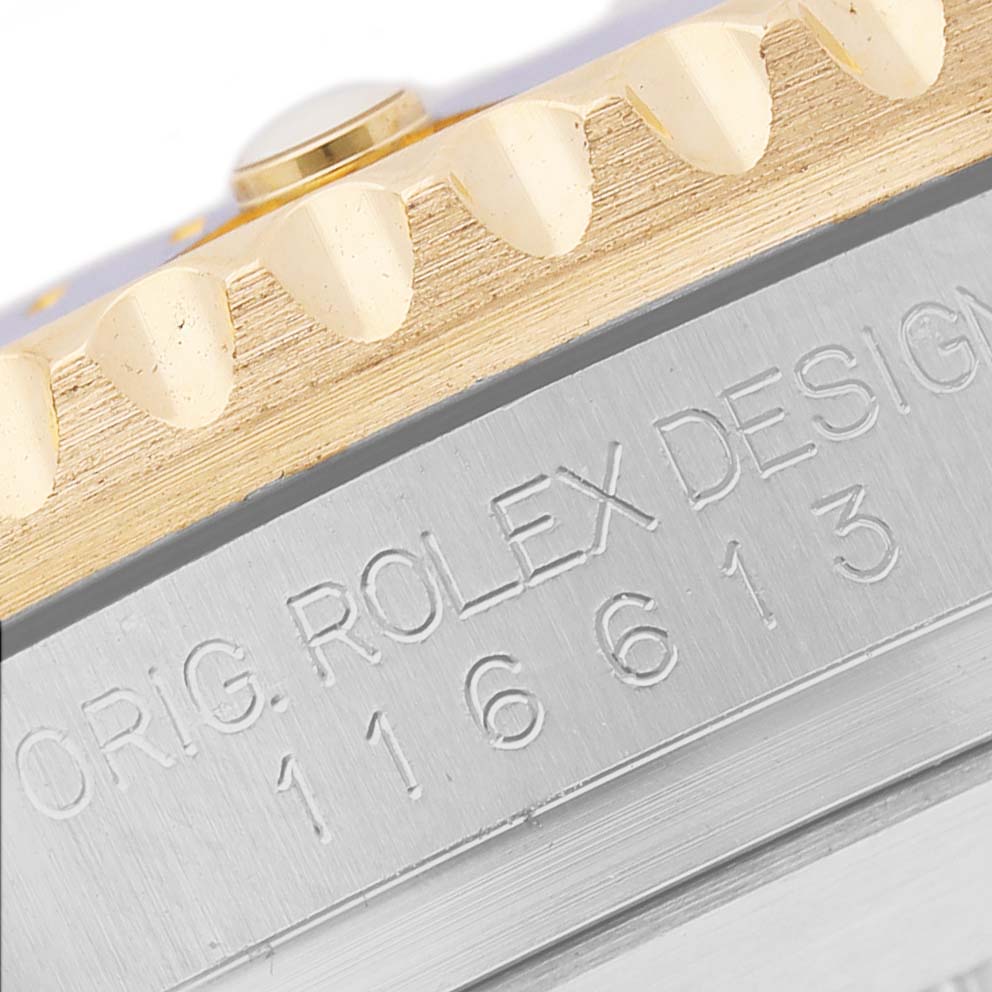 The image shows a close-up of the Rolex Submariner 116613 Men's Steel and Gold (two tone) Blue Dial's engraved case side and part of the gold bezel.
