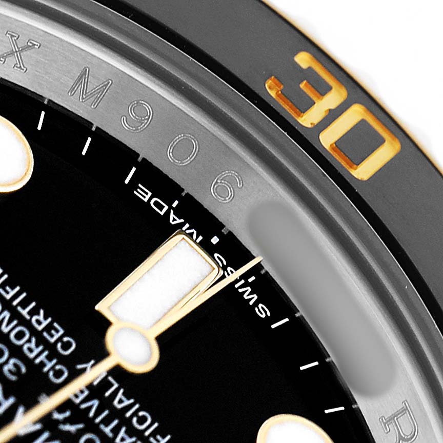 The image shows a close-up of the bezel, dial, and part of the hands of a Rolex Submariner 116613 Men's Steel and Gold (two tone) Black Dial.