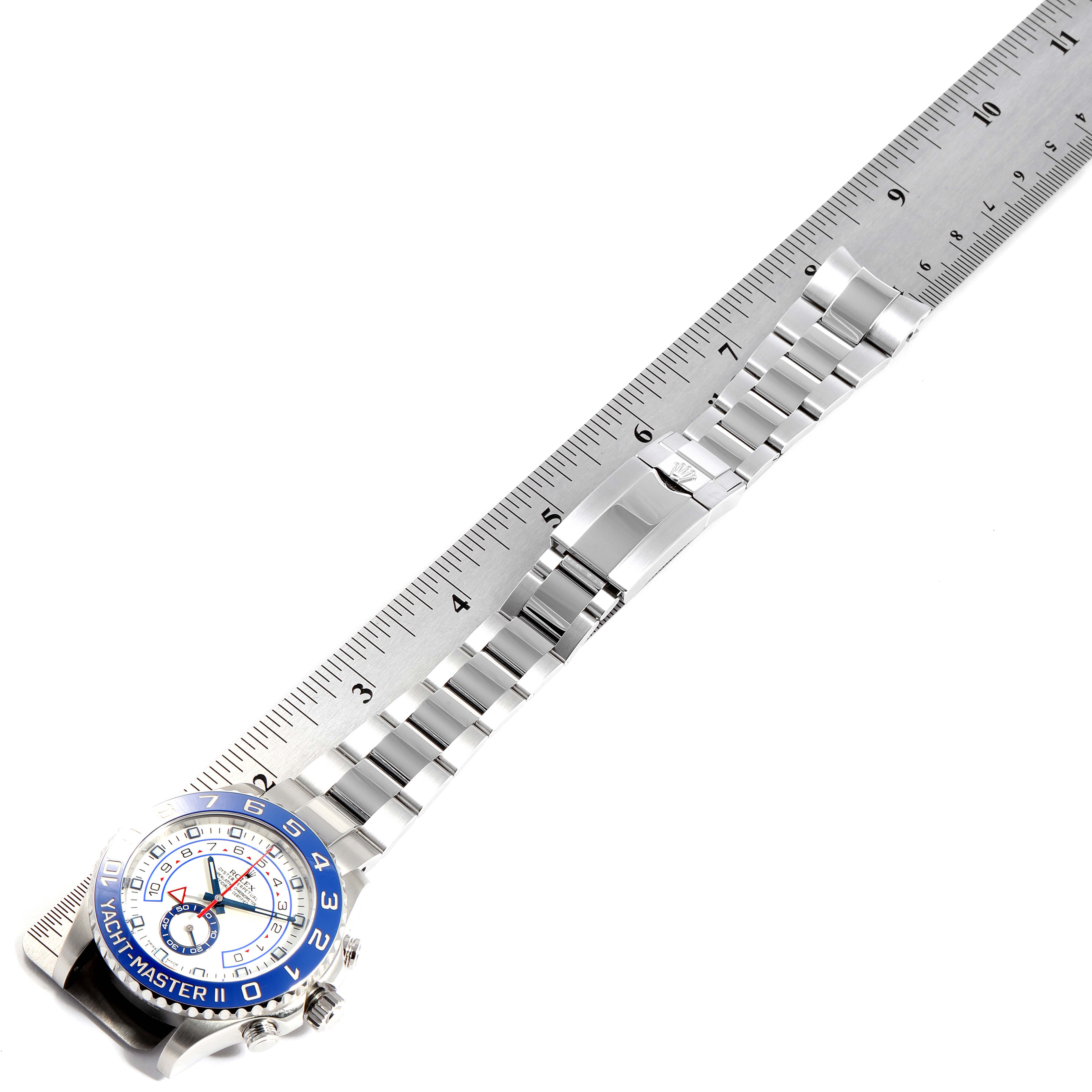 The image shows a top-down view of the Rolex Yacht-Master 116680 Men
s Stainless Steel White Dial 116680 Men
s Stainless Steel White Dial watch with its band fully extended alongside a ruler.