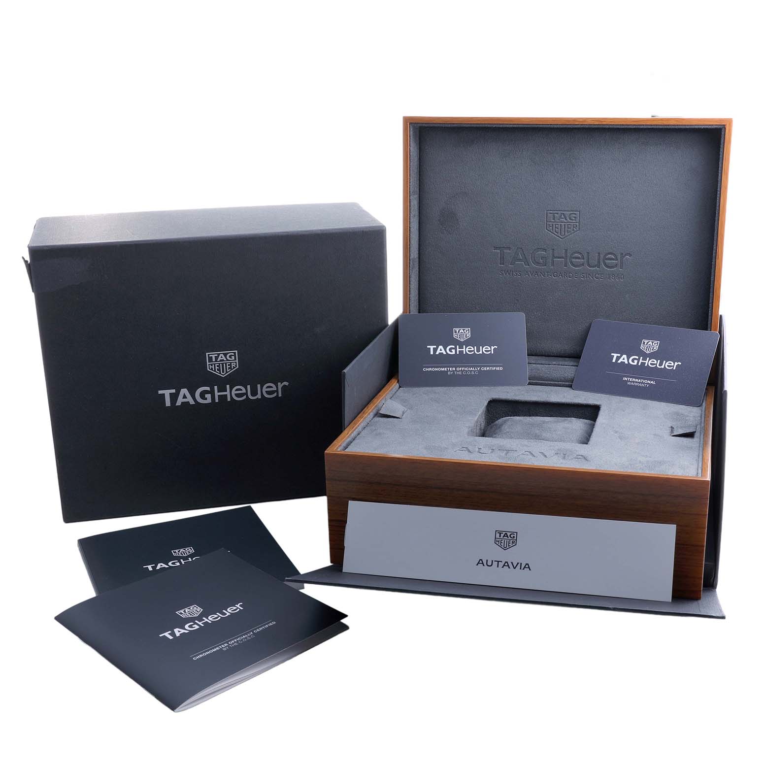 The image shows the packaging and accessories for a Tag Heuer Autavia CBE511B Men's Stainless Steel Silver Dial watch, including the box and documentation.