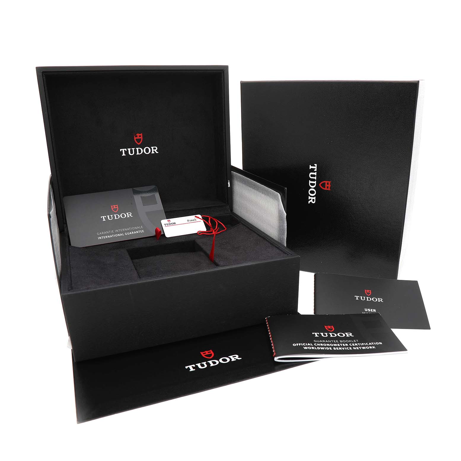 The image shows the Tudor Heritage Chrono 79360N Men's Stainless Steel Black Dial packaging, including the open box with manuals and tags, from a slightly elevated angle.