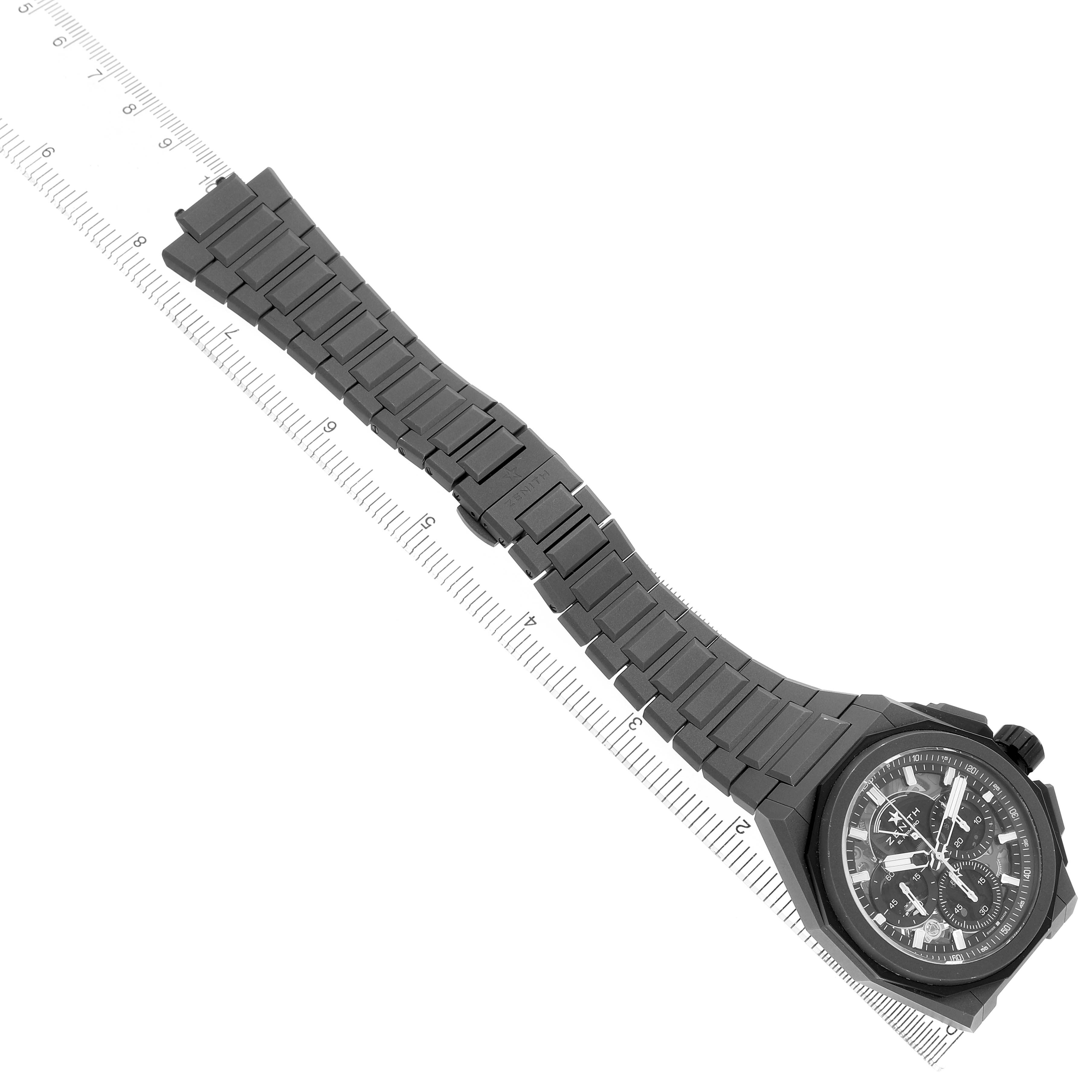 The Zenith Defy 97.9100.9004 Men's Titanium Grey Dial watch is shown at a top-down angle, displaying the entire bracelet and watch face aligned with a ruler.