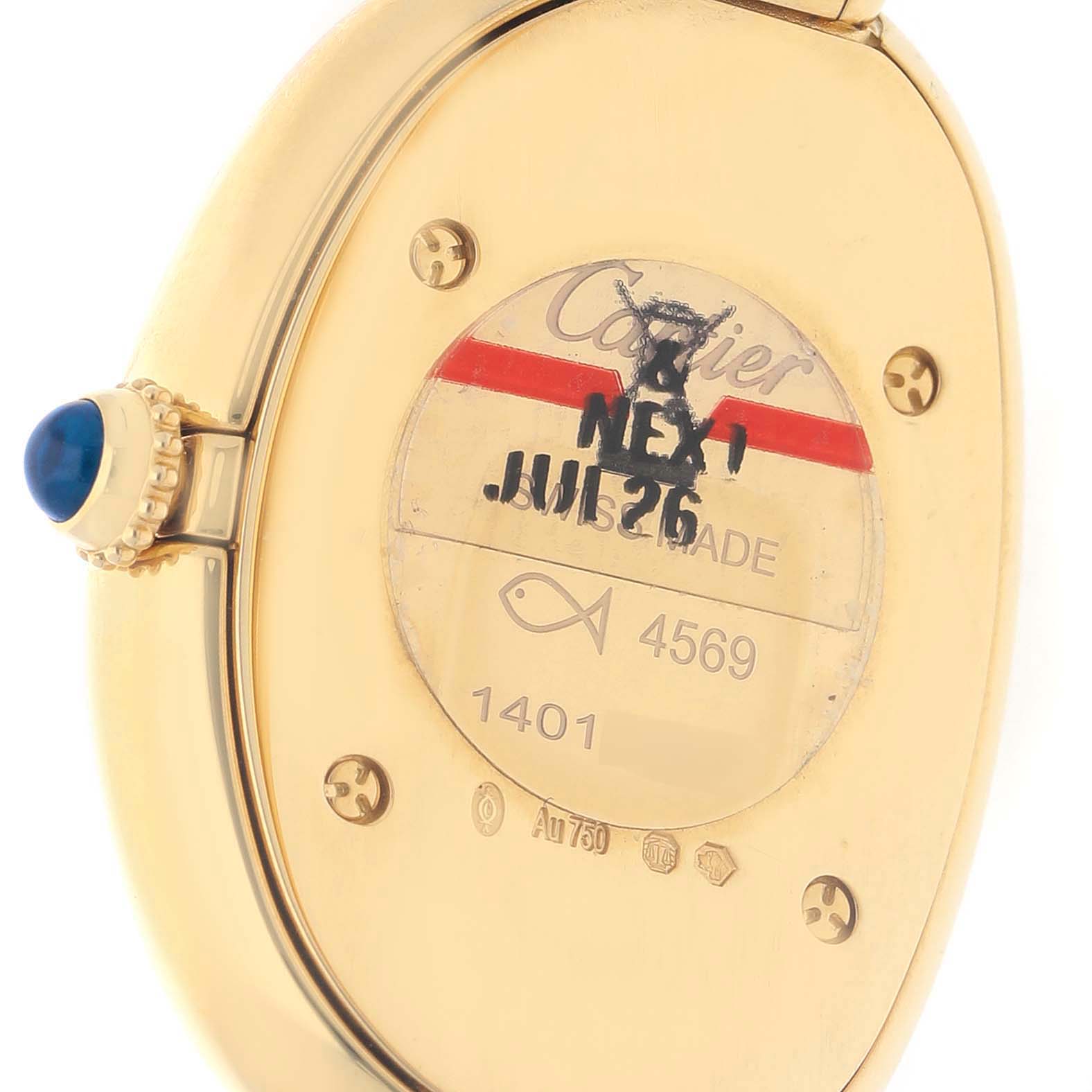 The image shows the back of a Cartier Baignoire WGBA0025 Women's Yellow Gold Silver Dial watch, highlighting the case, blue crown, and inscriptions.