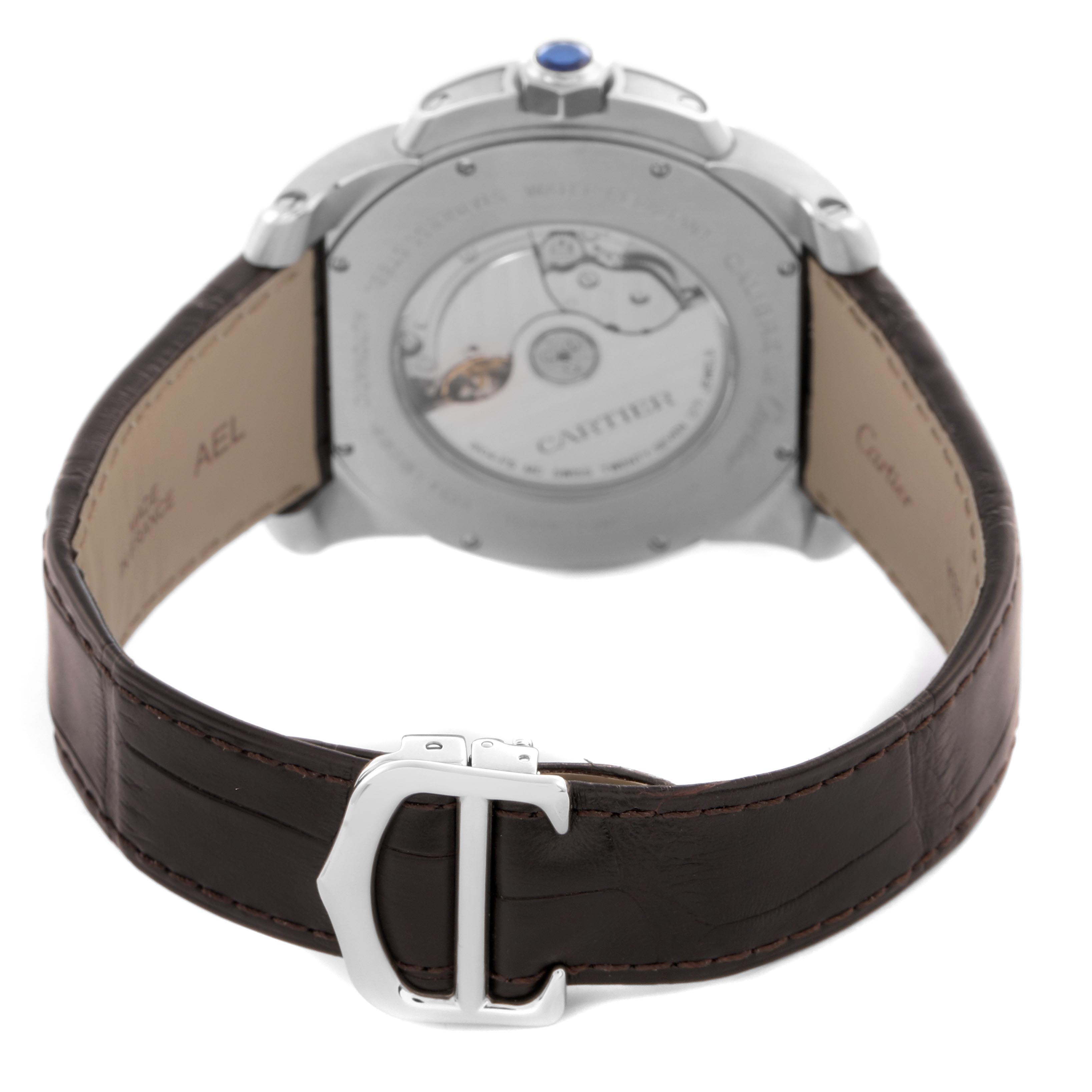 The image shows the back view of the Calibre de Cartier watch by Cartier, highlighting its transparent case back and leather strap.