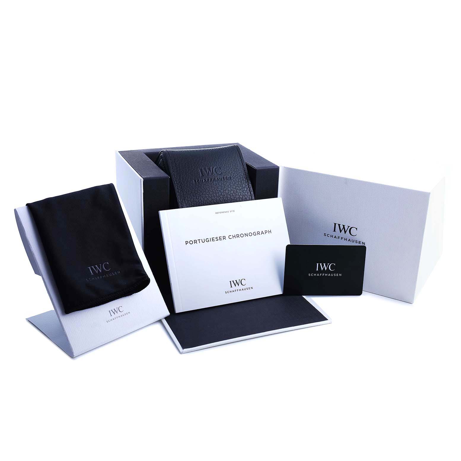 The image shows the IWC Portugieser packaging, including a box, booklet, card, and cloth from a slightly elevated angle.