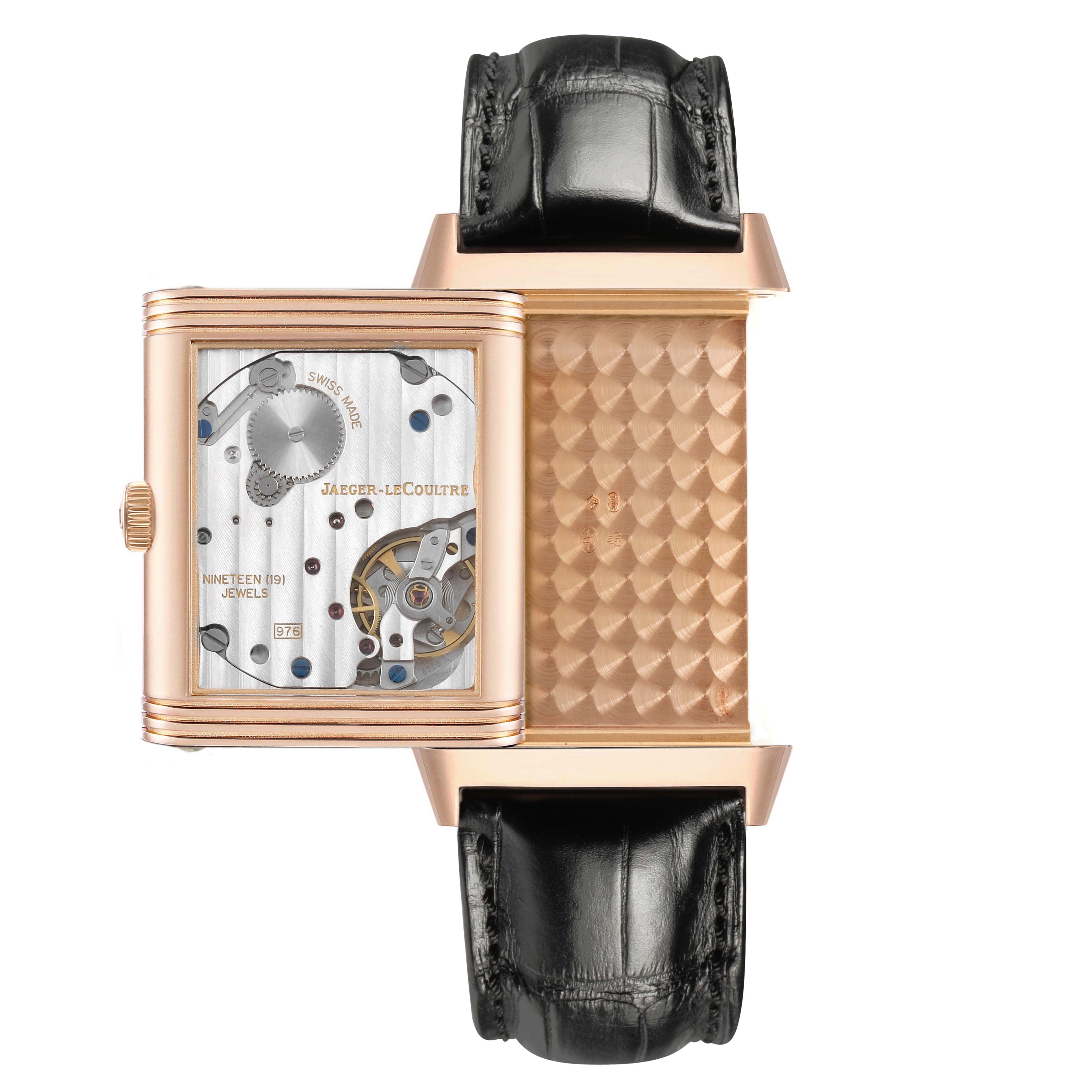 The Jaeger-LeCoultre Reverso watch is shown with its case flipped, revealing the inner mechanism.