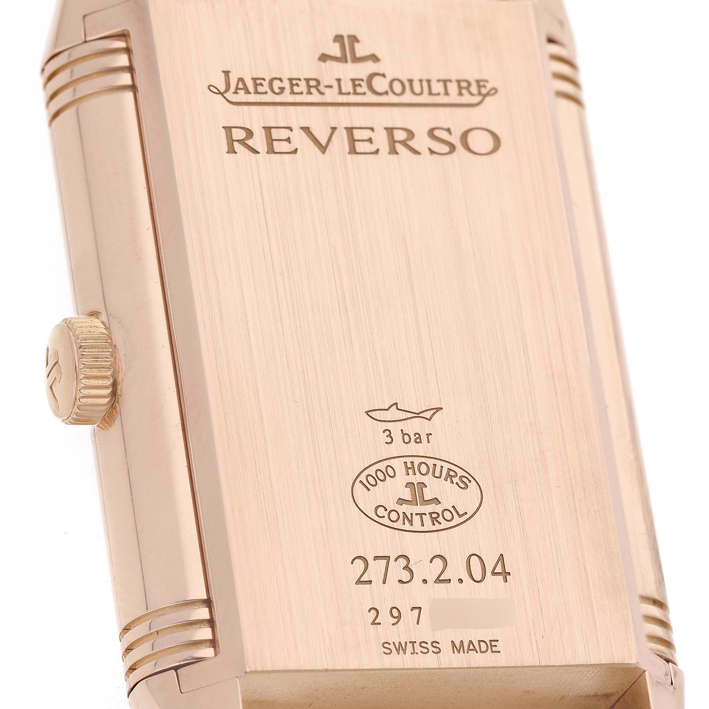 The image shows the back of the Jaeger-LeCoultre Reverso watch at an angled view, highlighting the case, crown, and engravings.