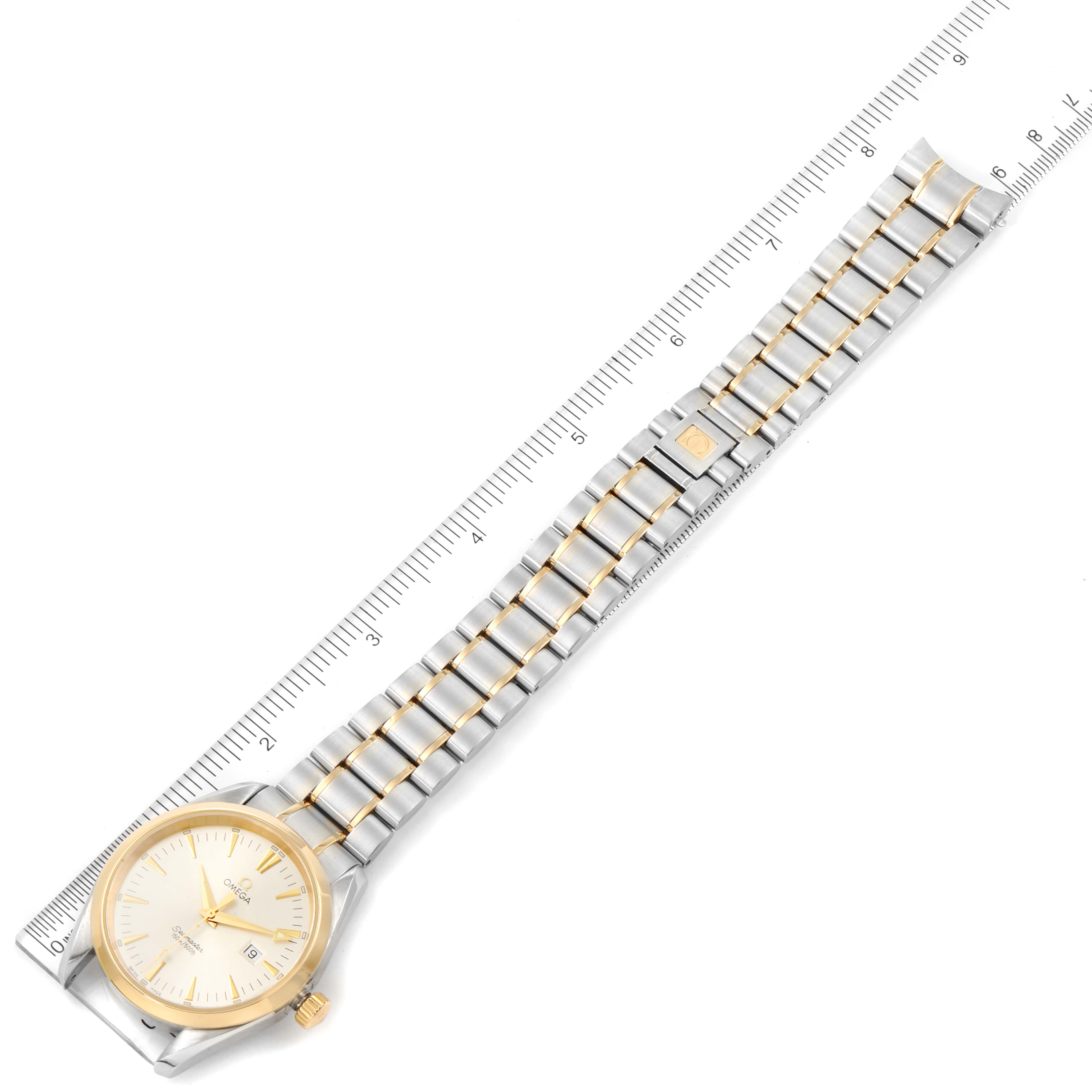 This image shows an Omega Aqua Terra 2317.30.00 Men
s Stainless Steel Silver Dial 2317.30.00 Men
s Stainless Steel Silver Dial watch laid flat next to a ruler, displaying its face and metal bracelet.