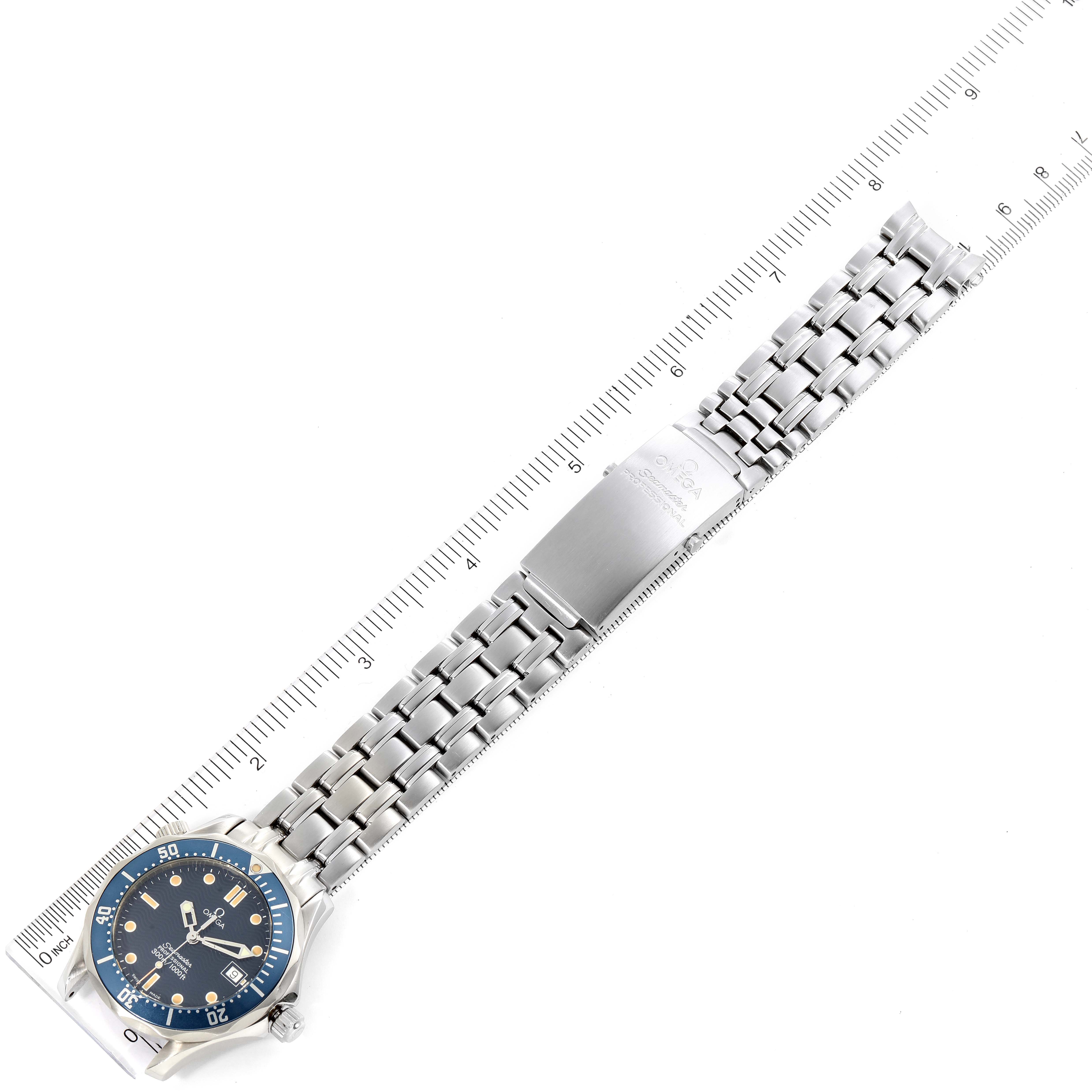 The Omega Seamaster 2561.80.00 Men
s Stainless Steel Blue Dial 2561.80.00 Men
s Stainless Steel Blue Dial watch is shown from a top-down angle, displaying its dial and metal bracelet against a ruler for scale.