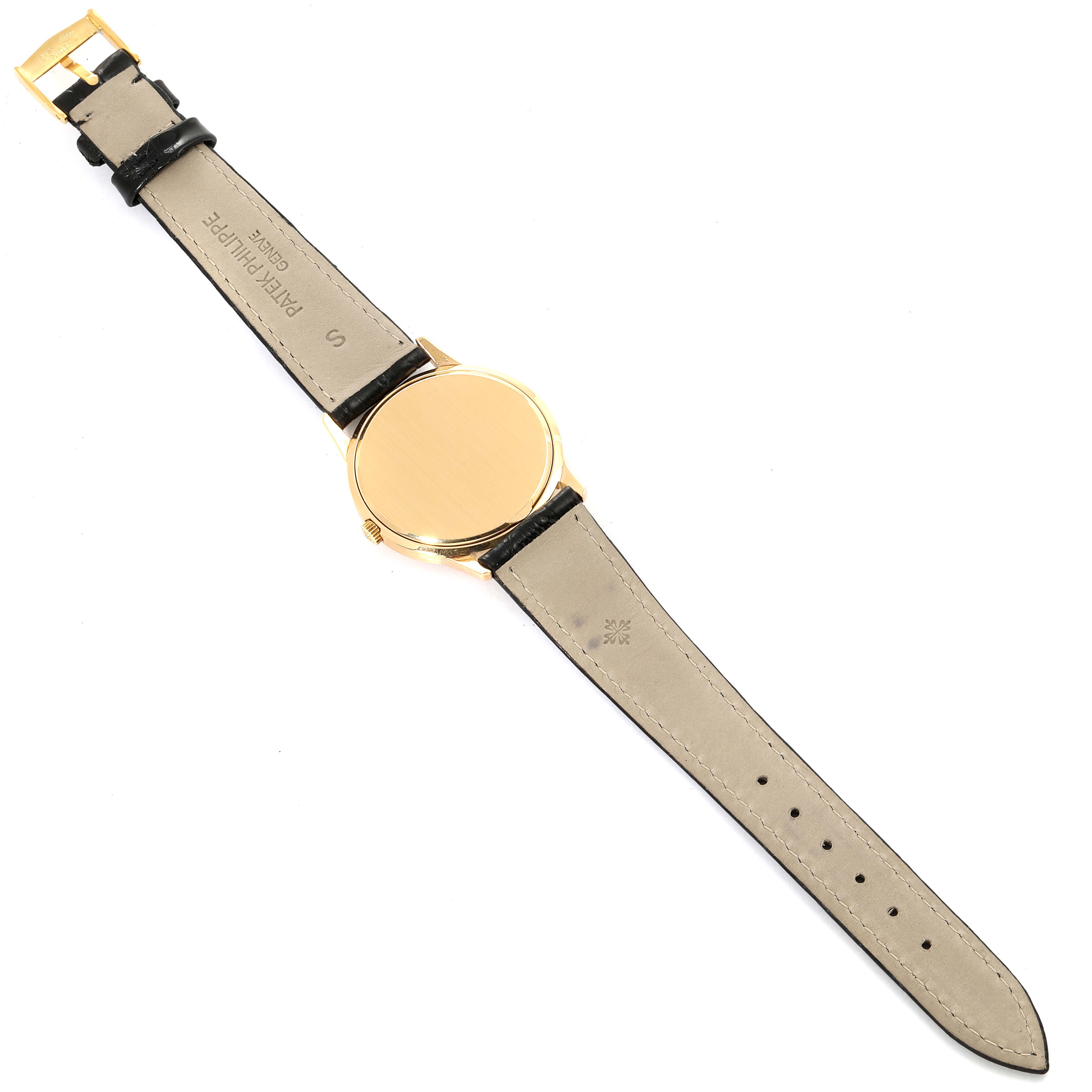 This image shows the back view of a vintage Patek Philippe watch, displaying the case back and leather strap.