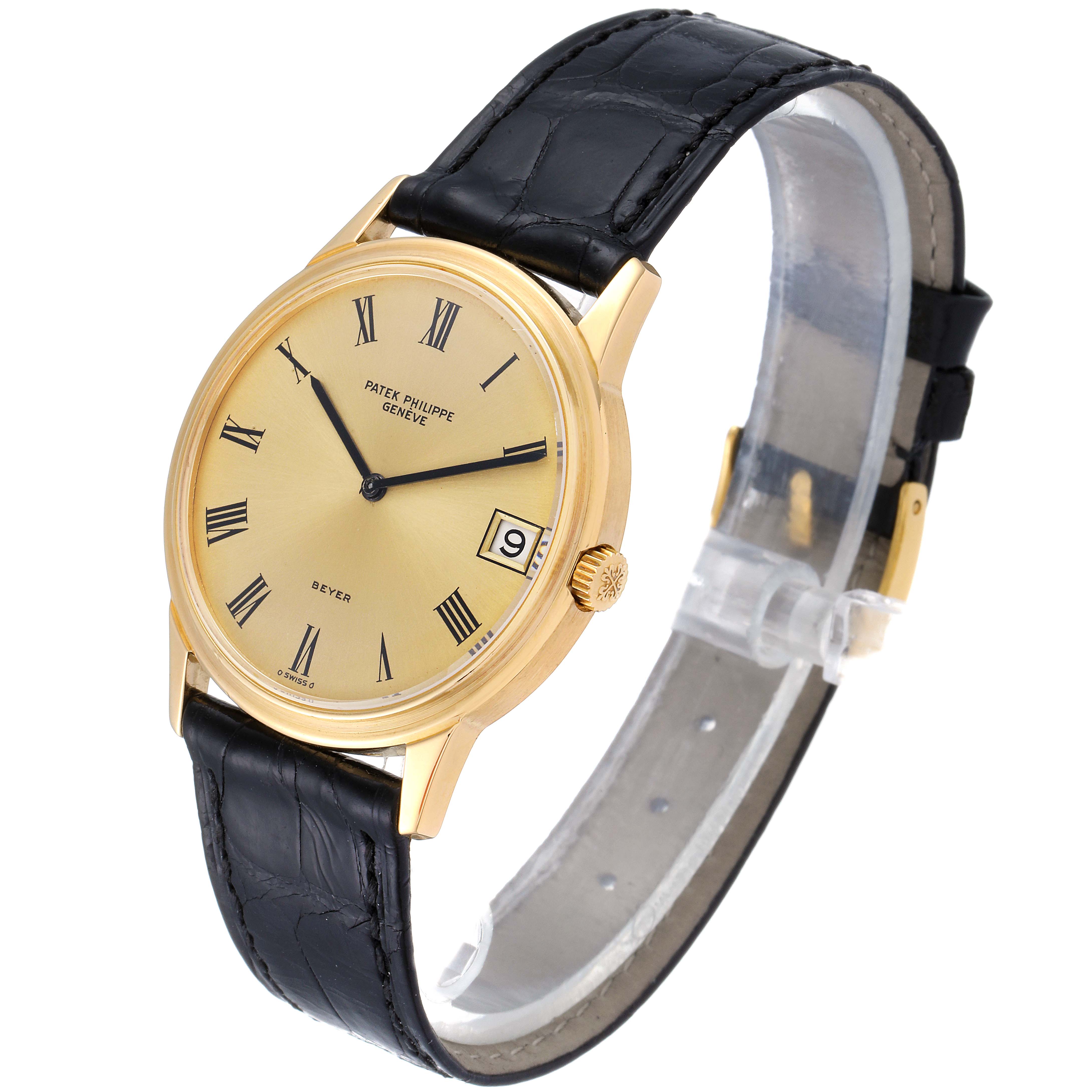 Displayed at a three-quarter angle, the Vintage Patek Philippe watch showcases its face, gold casing, black leather strap, and side crown.