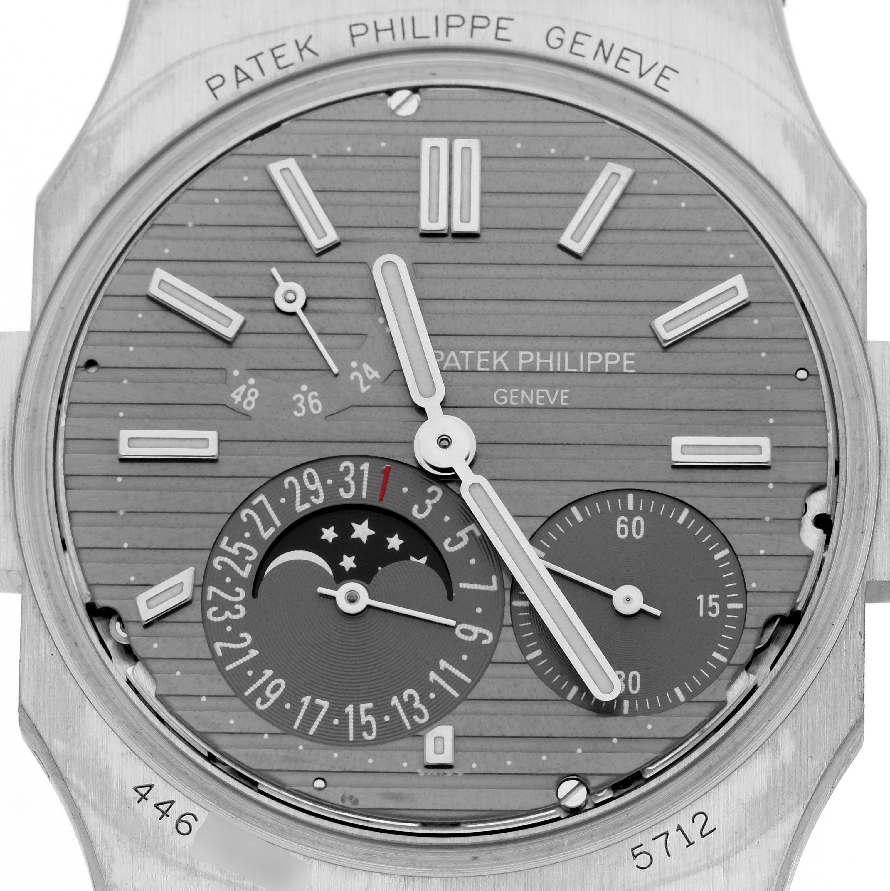 The image shows a close-up of the Patek Philippe Nautilus 5712G-001 Men's White Gold Grey Dial 5712G-001 Men's White Gold Grey Dial watch face, highlighting the dial, moon phase, and subdials.