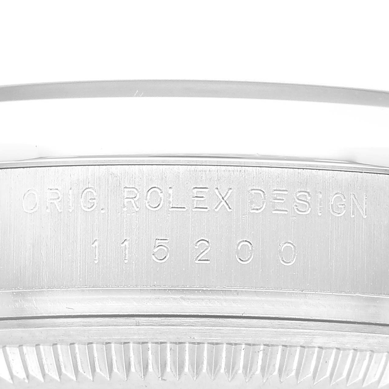 The image shows the side view of a Rolex Date 115200 Men's Stainless Steel Blue Dial model, focusing on the engraved bezel.