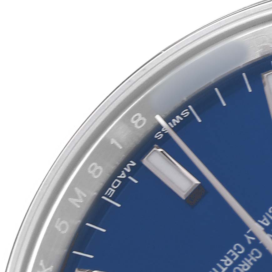 The image shows a partial view of the dial and bezel of a Rolex Date 115200 Men's Stainless Steel Blue Dial watch, featuring markers and part of the seconds hand.