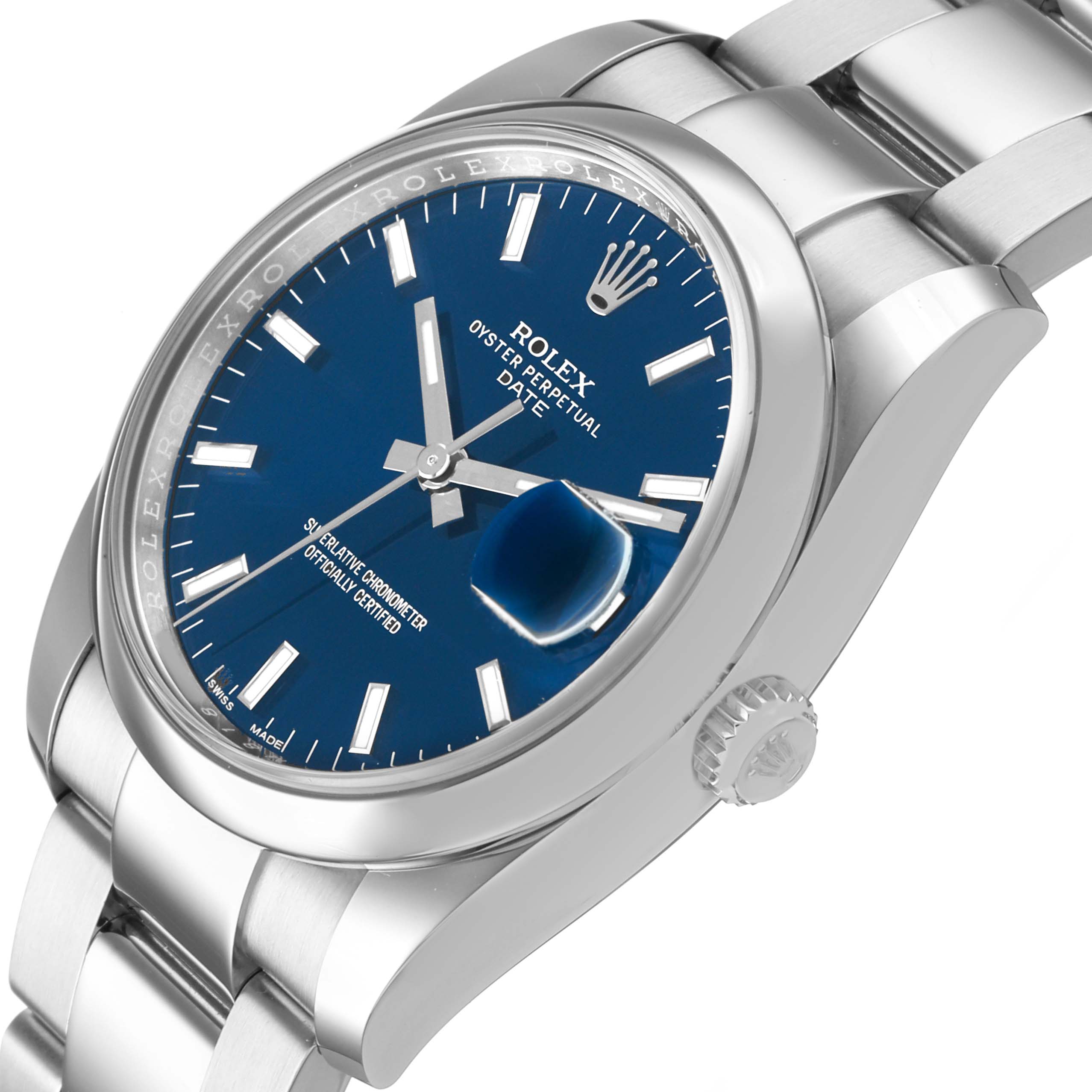 The Rolex Date 115200 Men's Stainless Steel Blue Dial model watch is shown at an angled side view, highlighting the dial, bezel, bracelet, and crown.
