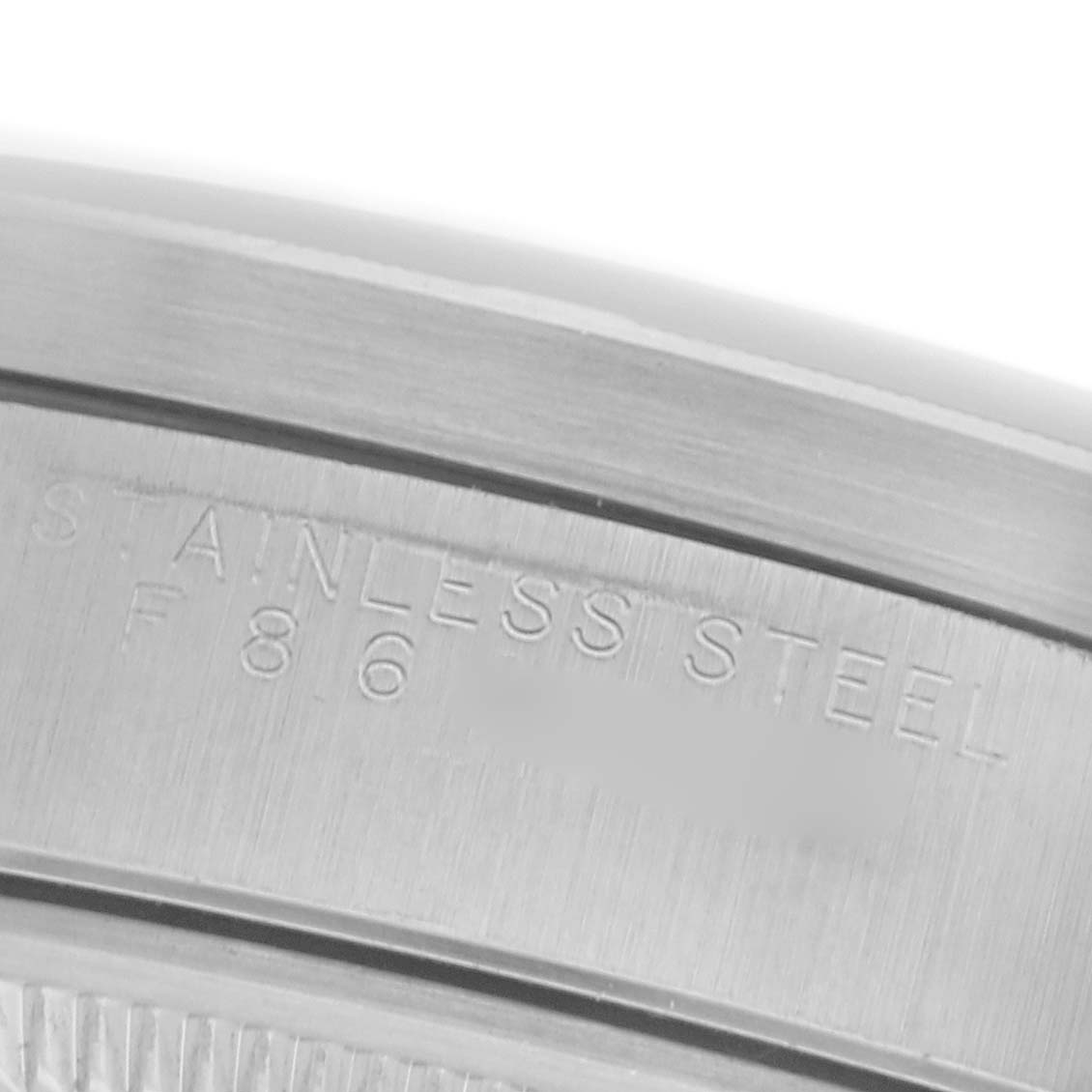 The image shows an angled view of the inner bezel of a Rolex Date 15210 Men
s Stainless Steel Silver Dial 15210 Men
s Stainless Steel Silver Dial watch, highlighting the "STAINLESS STEEL" engraving.