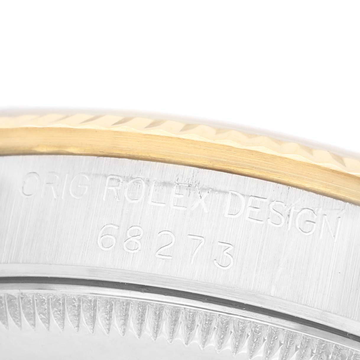 The image shows a close-up of the case edge of a Rolex Mid-Size 68273 Women's Steel and Gold (two tone) White Dial watch, featuring the model number and design engraving.