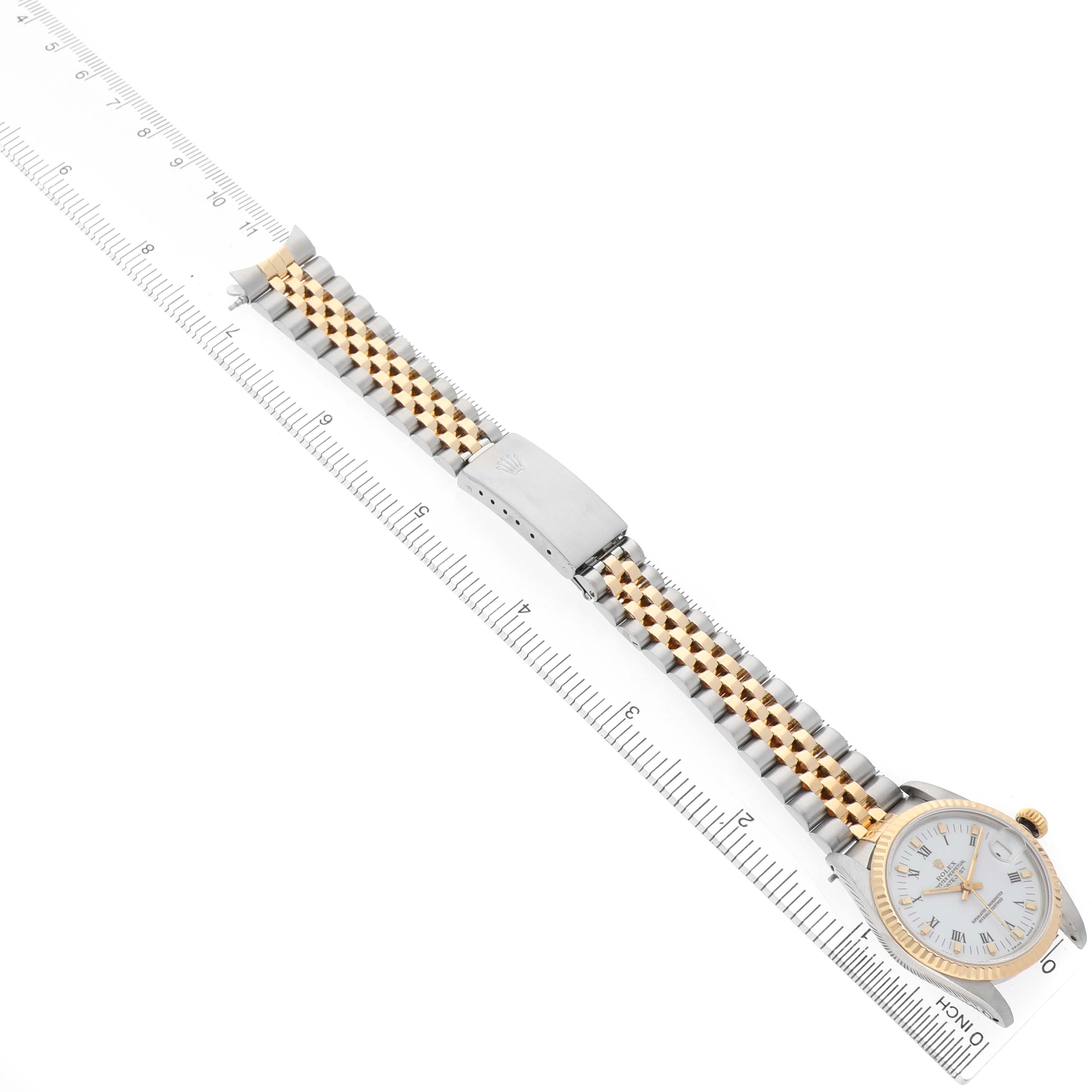 The Rolex Mid-Size 68273 Women's Steel and Gold (two tone) White Dial watch is shown at an angle displaying the face, bezel, and jubilee bracelet alongside a ruler for scale.