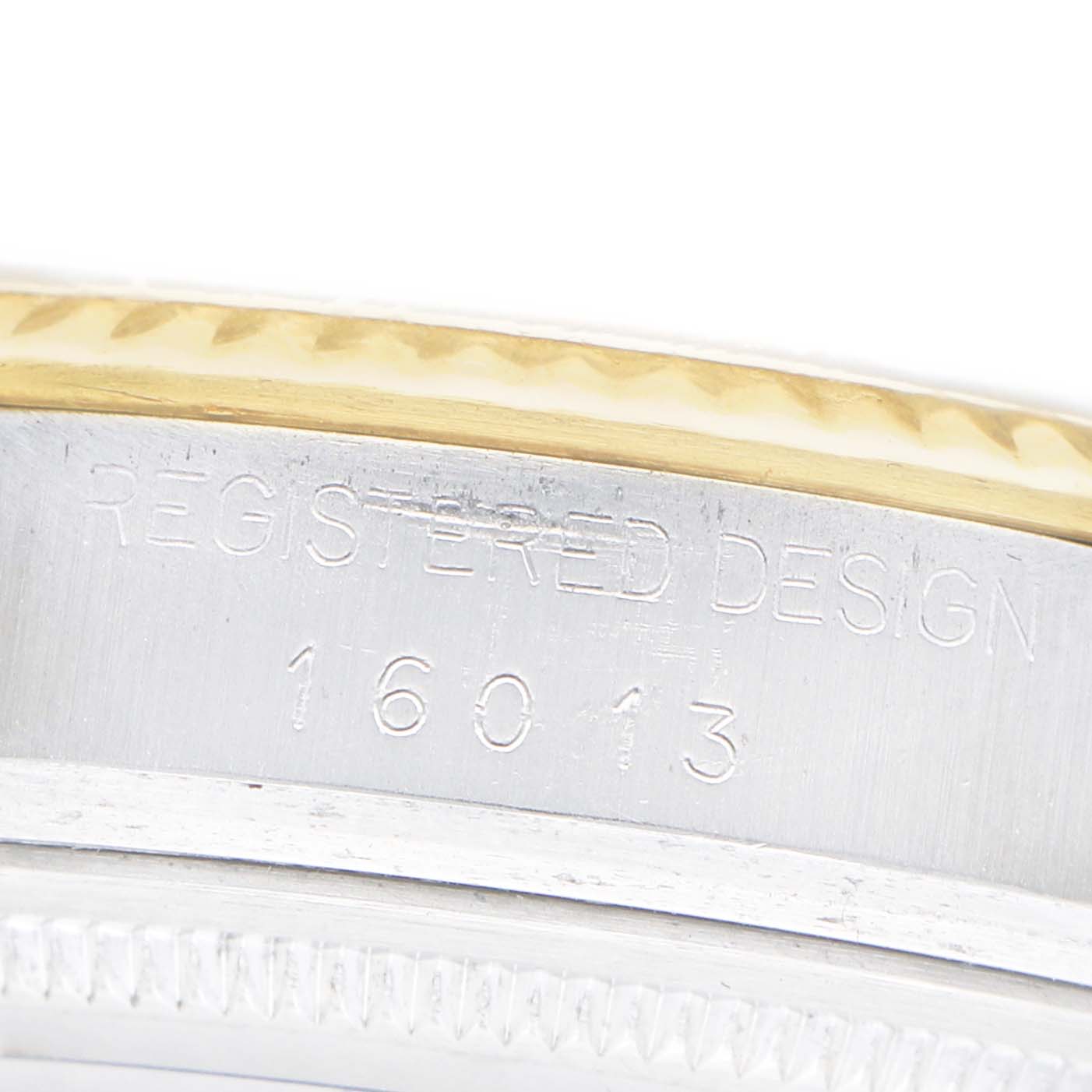 The image shows a close-up of the side engraving on the bezel of a Rolex Datejust 16013 Men's Steel and Gold (two tone) White Dial watch, featuring "REGISTERED DESIGN 16013."