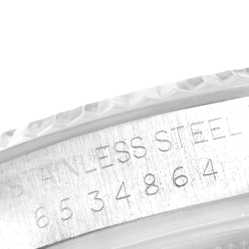 The image shows a close-up of the serial number and "STAINLESS STEEL" engraving on the bezel of a Vintage Collection model by Rolex.