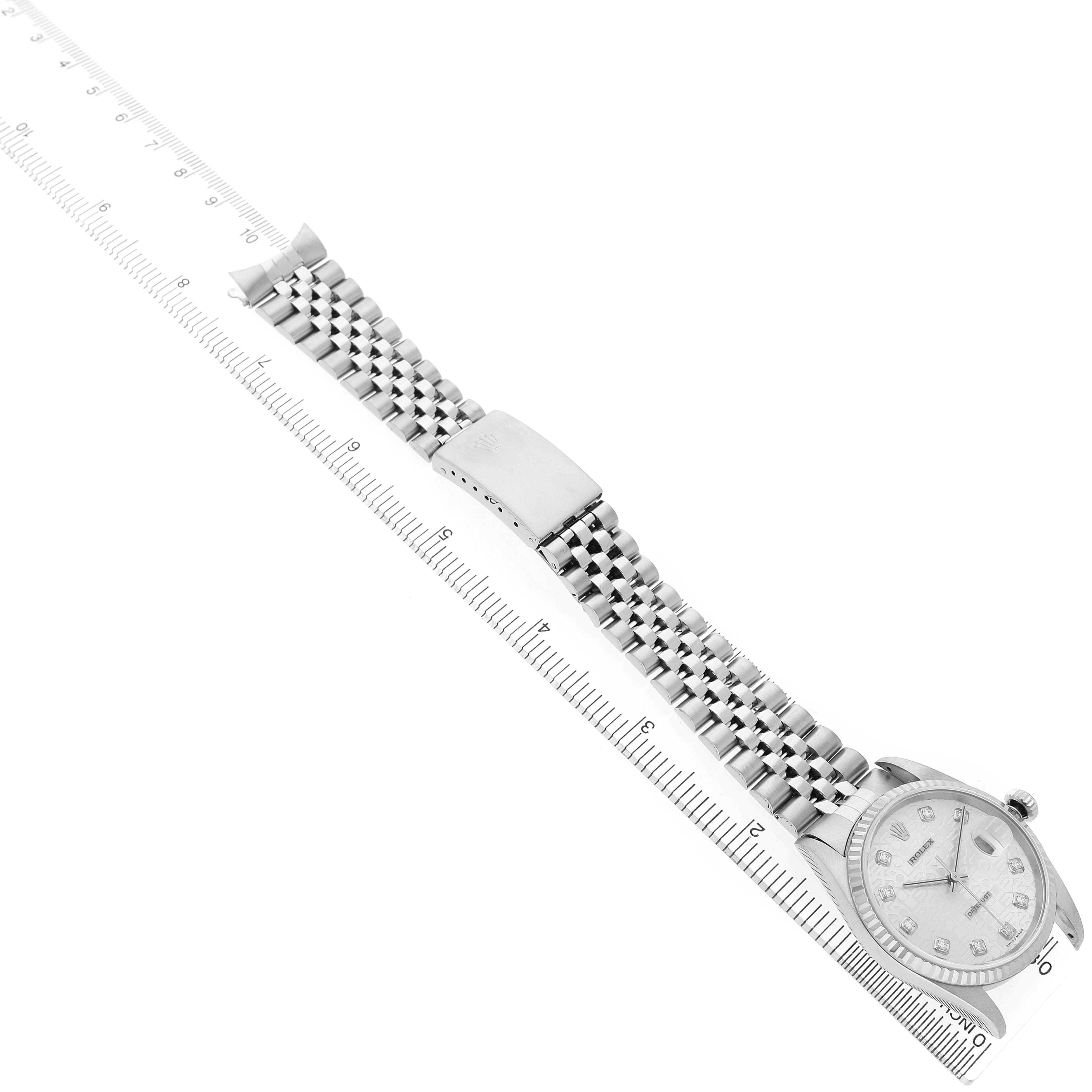 The image shows a Rolex Datejust 16234 Men's Stainless Steel Silver Dial watch at an oblique angle, focusing on the face and full bracelet alongside a ruler.