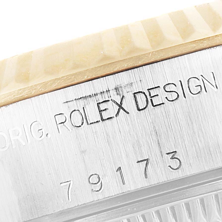 This image shows a close-up of the side of a Rolex Datejust 79173 Women's Steel and Gold (two tone) Mother of Pearl Dial 79173 Women's Steel and Gold (two tone) Mother of Pearl Dial watch case, highlighting the engraved text and partial serial number.