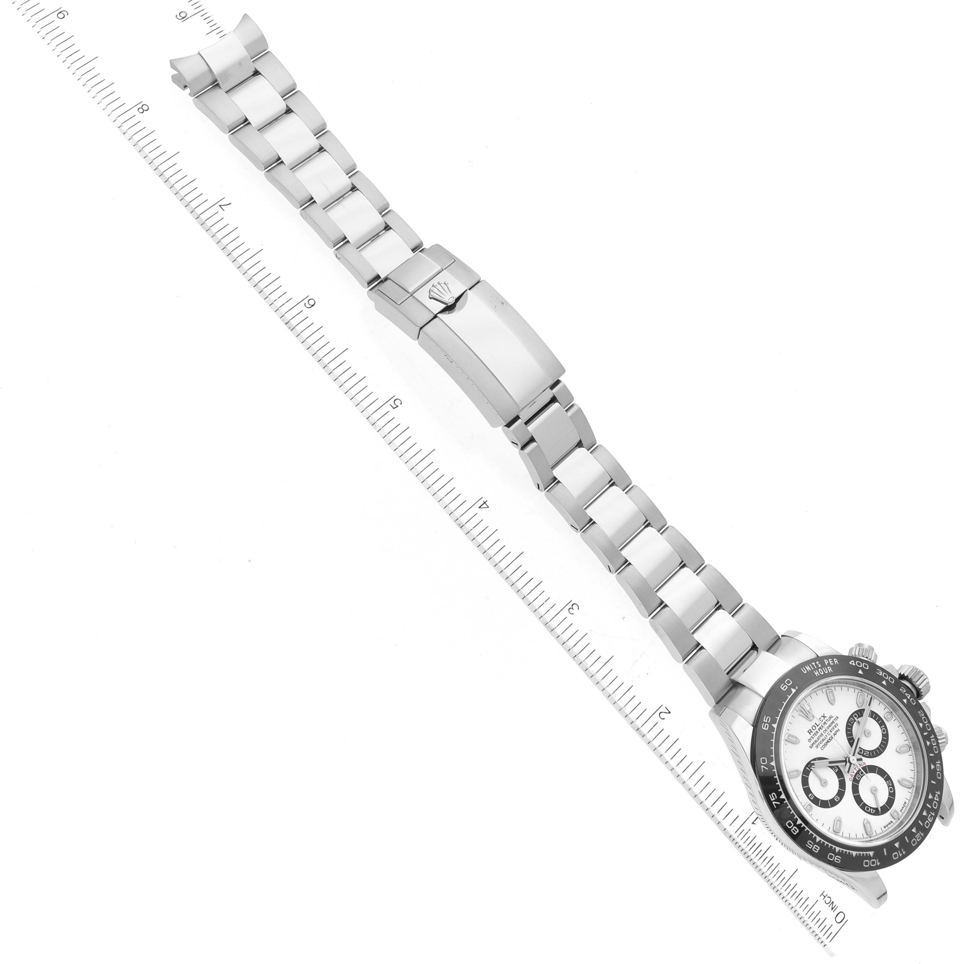 The Rolex Daytona 116500LN Men's Stainless Steel White Dial 116500LN Men's Stainless Steel White Dial watch is shown laid flat, with its bracelet extended alongside a ruler for size reference.