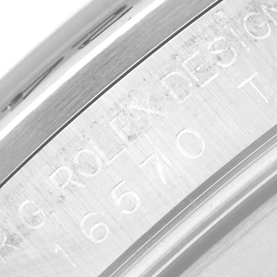 The image shows a close-up of the engraved serial number and "ROLEX DESIGN" text on the side of a Rolex Explorer 16570T Men
s Stainless Steel Black Dial 16570T Men
s Stainless Steel Black Dial model watch.