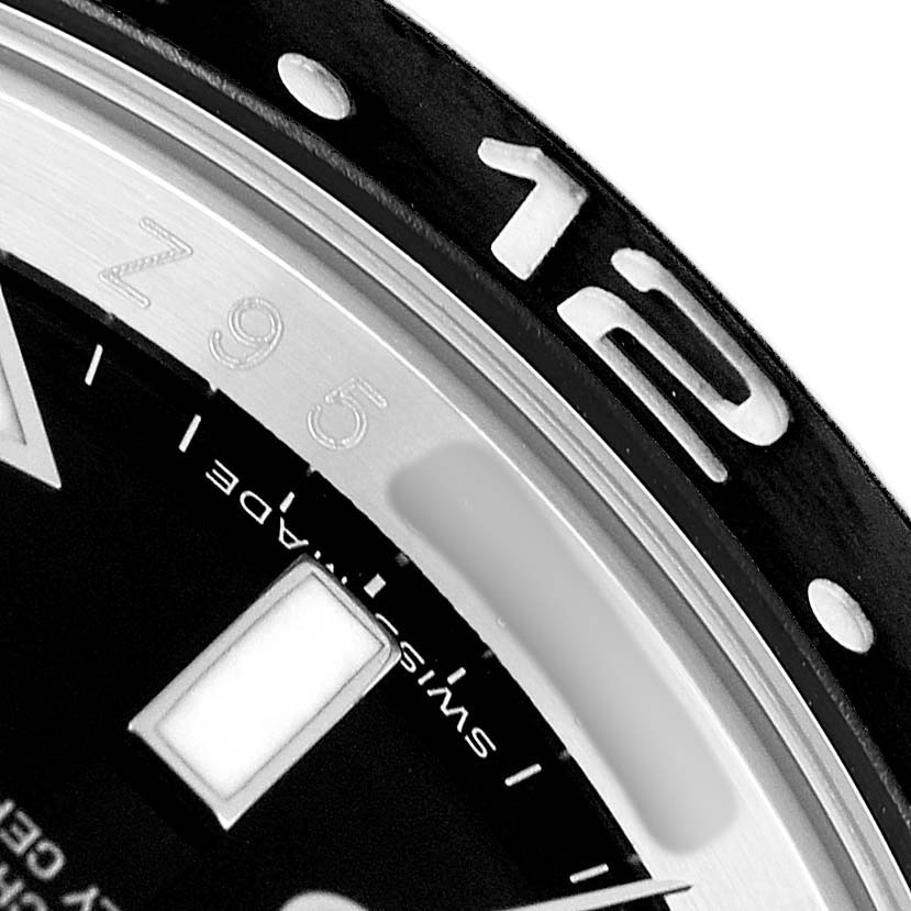 The image shows a close-up of the bezel and dial edge of a Rolex GMT-Master 116710 Men's Stainless Steel Black Dial, focusing on the "12" marker.