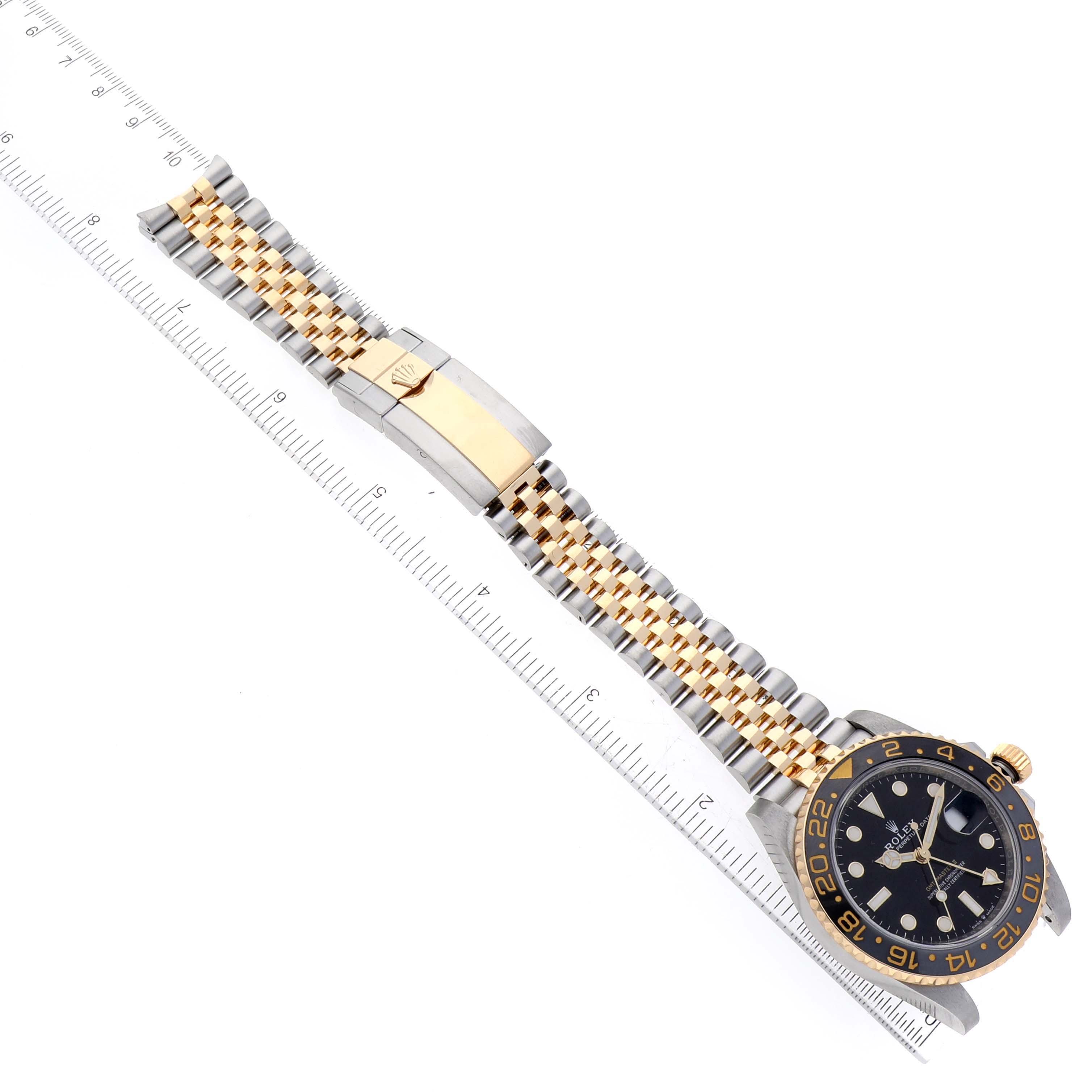 The image shows a Rolex GMT-Master 126713GRNR Men's Steel and Gold (two tone) Black Dial 126713GRNR Men's Steel and Gold (two tone) Black Dial watch laid flat, displaying the face, bezel, and two-tone bracelet.