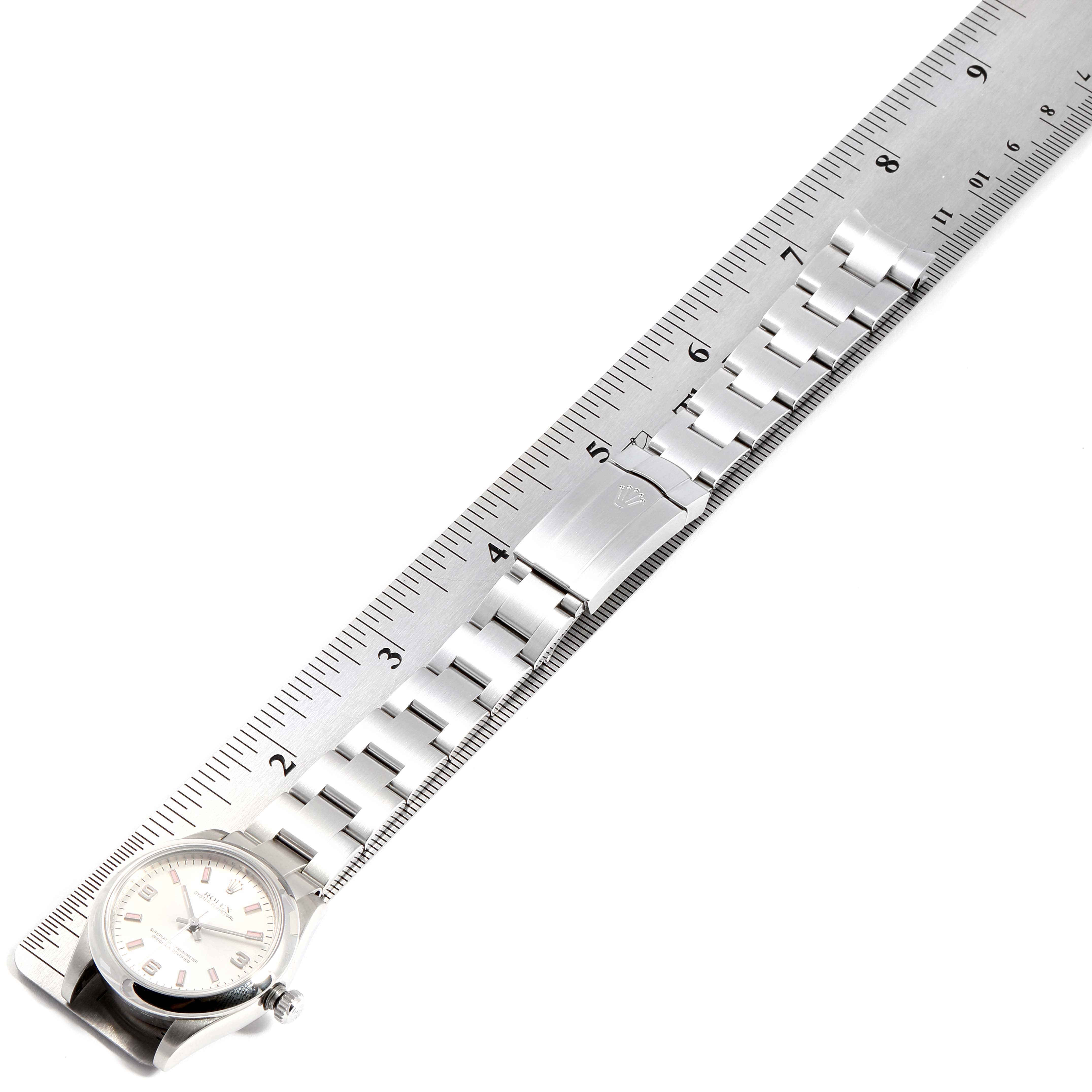 This image shows a Rolex Mid-Size 177200 Women
s Stainless Steel Silver Dial 177200 Women
s Stainless Steel Silver Dial watch laid flat with its bracelet and clasp visible alongside a measuring ruler.