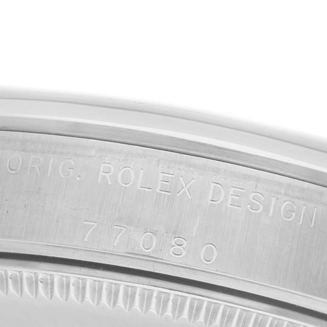 The image shows a close-up of the case back edge of a Rolex Mid-Size 77080 Women's Stainless Steel White Dial 77080 Women's Stainless Steel White Dial model, featuring engraved text.