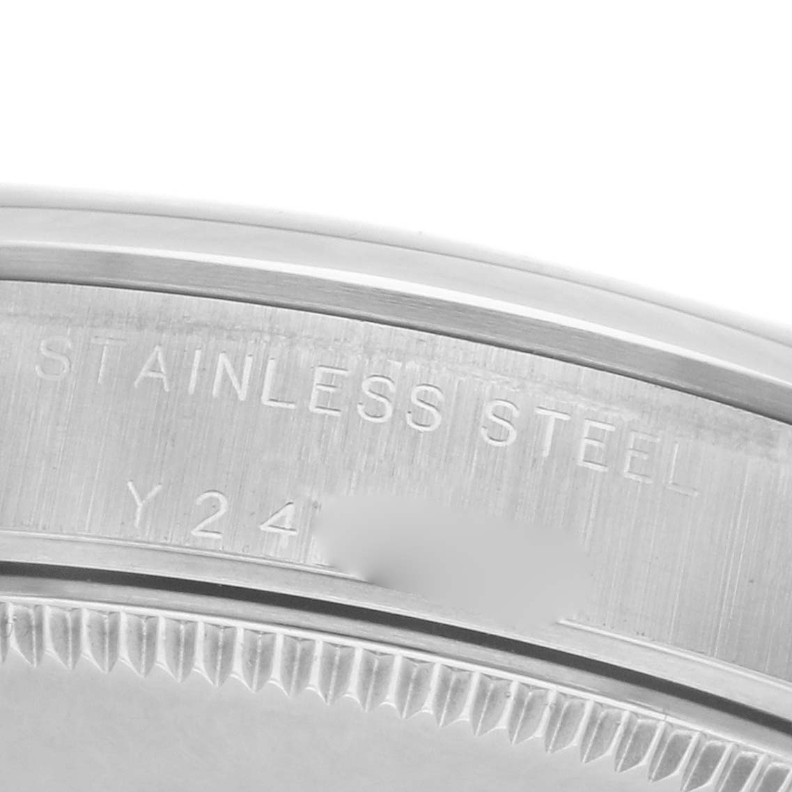 This image shows a close-up of the case back of a Rolex Mid-Size 77080 Women's Stainless Steel White Dial 77080 Women's Stainless Steel White Dial model, highlighting "STAINLESS STEEL" engraving.