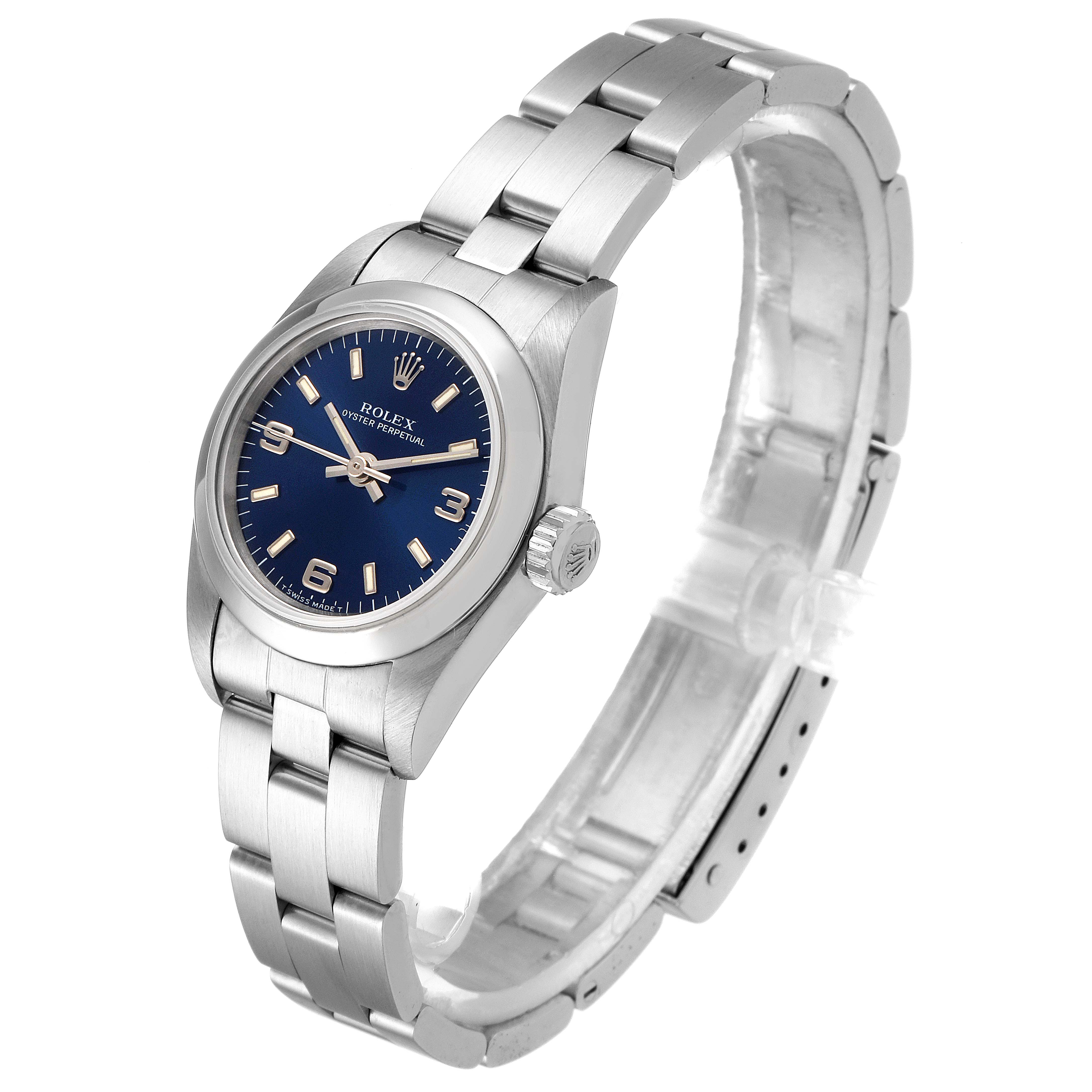 The Rolex Oyster Perpetual 67180 Women
s Stainless Steel Blue Dial 67180 Women
s Stainless Steel Blue Dial watch is shown at an angle displaying its face, side, and partially open bracelet.