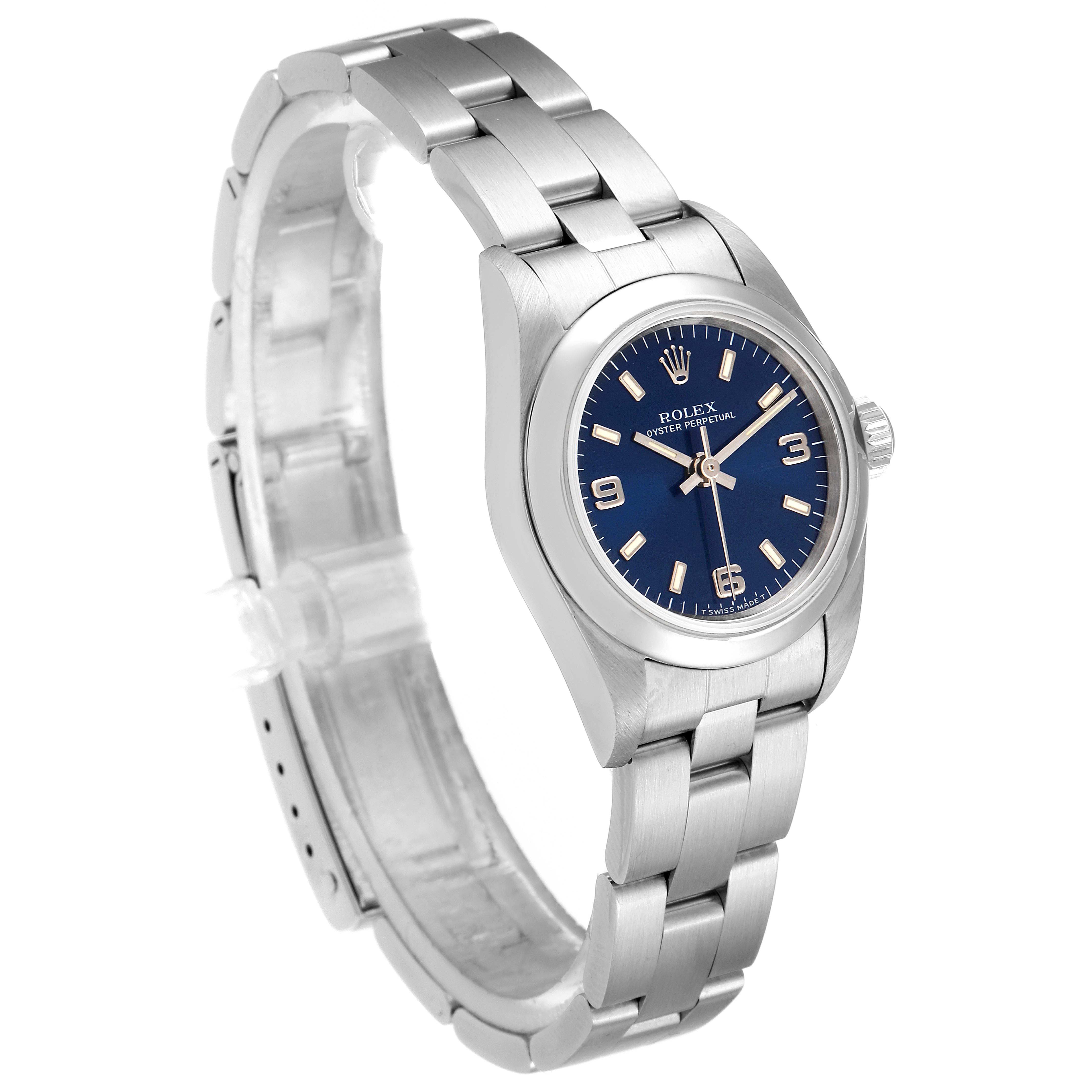 The image shows a Rolex Oyster Perpetual 67180 Women
s Stainless Steel Blue Dial 67180 Women
s Stainless Steel Blue Dial watch at an angled side view, displaying its bracelet, case, crown, and blue dial.