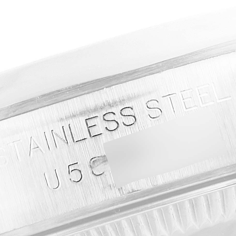 This image shows a close-up angle of the engraved text on the stainless steel back of a Rolex Oyster Perpetual 67180 Women's Stainless Steel White Dial 67180 Women's Stainless Steel White Dial watch.
