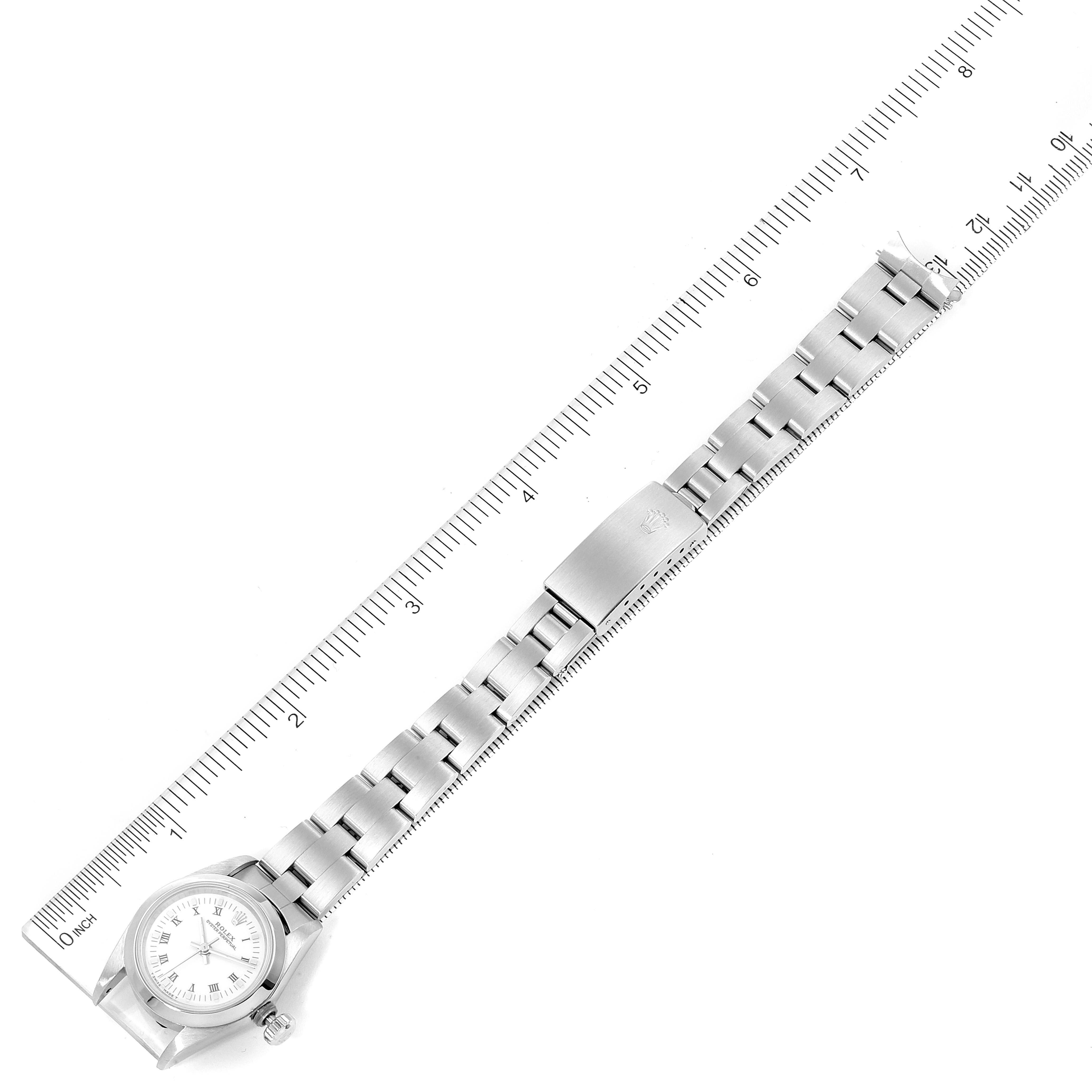 The image shows a top-down view of a Rolex Oyster Perpetual 67180 Women's Stainless Steel White Dial 67180 Women's Stainless Steel White Dial watch with part of its stainless steel bracelet.